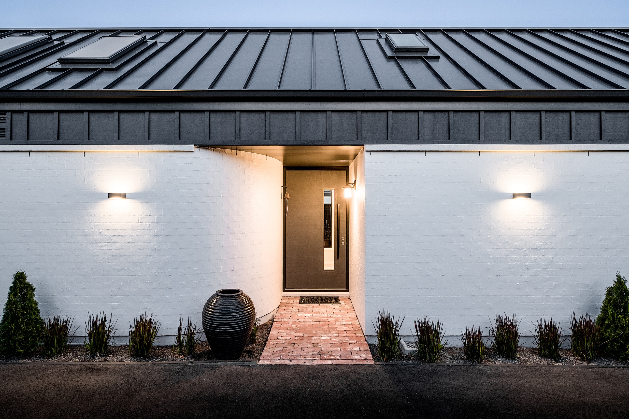 White bagged brick cladding grounds the house to 