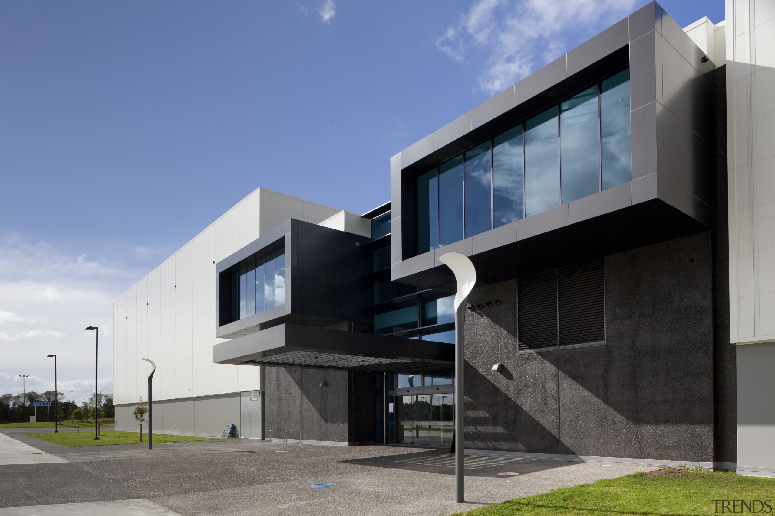 Exterior with dark grey cladding. - Exterior with architecture, building, commercial building, corporate headquarters, elevation, facade, headquarters, home, house, real estate, residential area, teal, gray, black