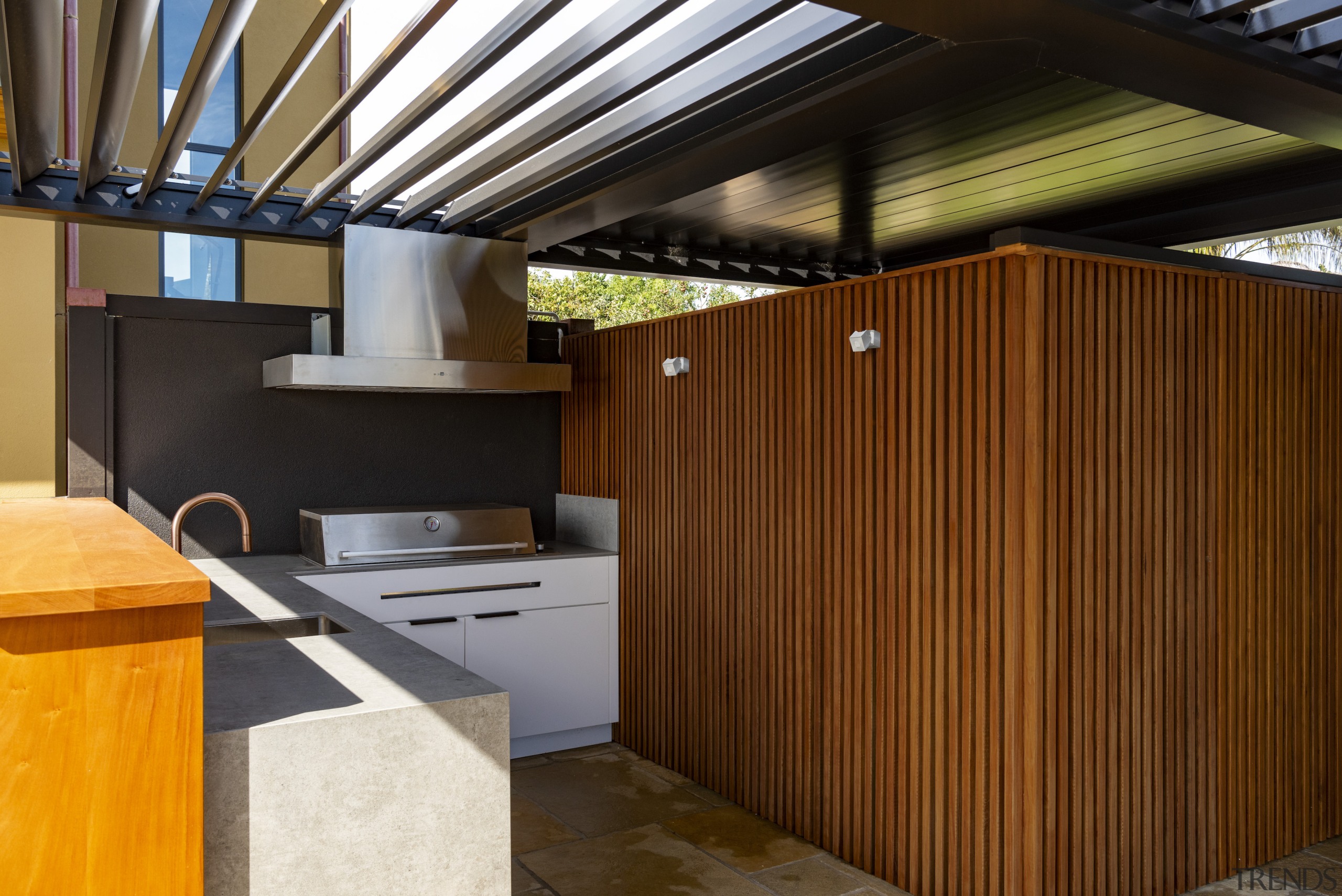 The outdoor kitchen with operable louvres overhead. 