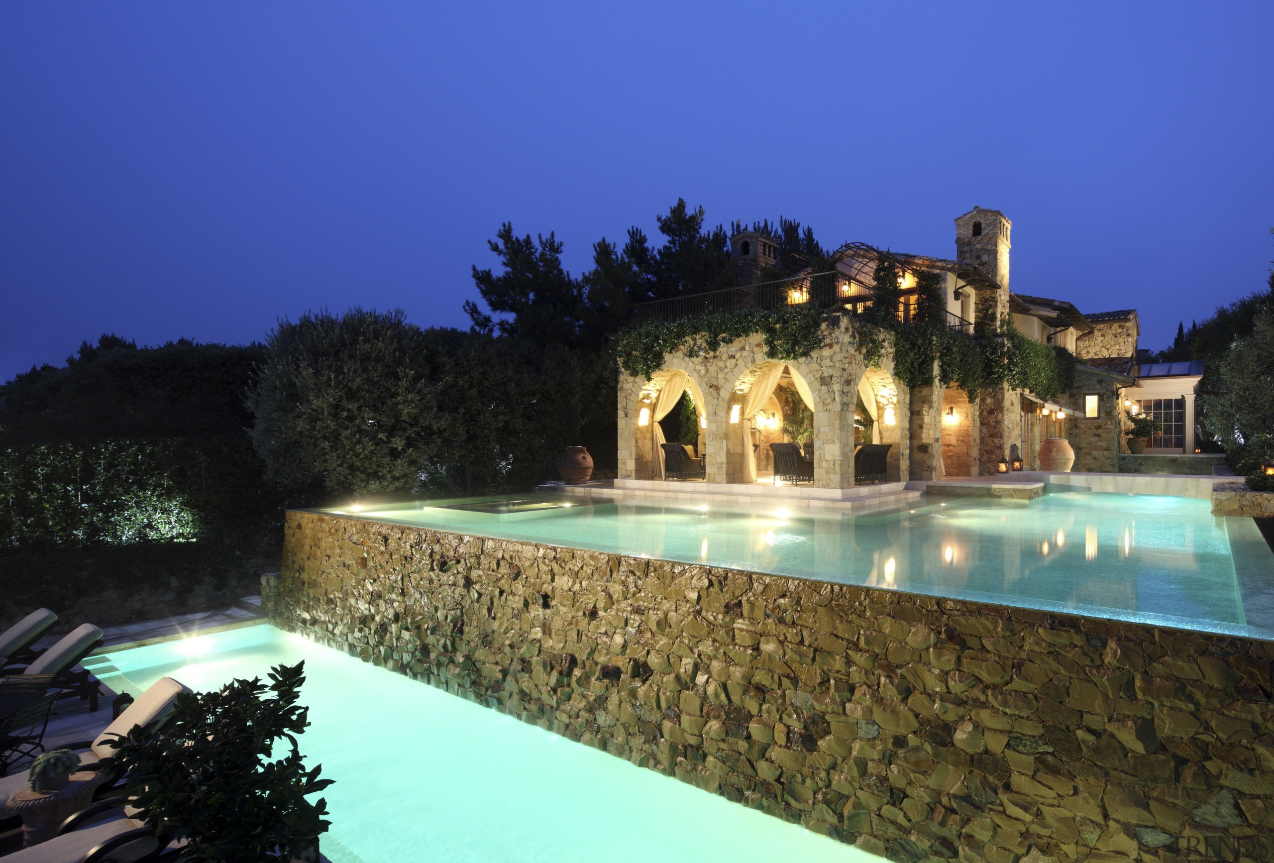 Exterior view of house with pool and stone estate, hacienda, home, hotel, landscape lighting, leisure, lighting, mansion, night, property, real estate, reflection, resort, resort town, sky, swimming pool, villa, water, water feature, blue