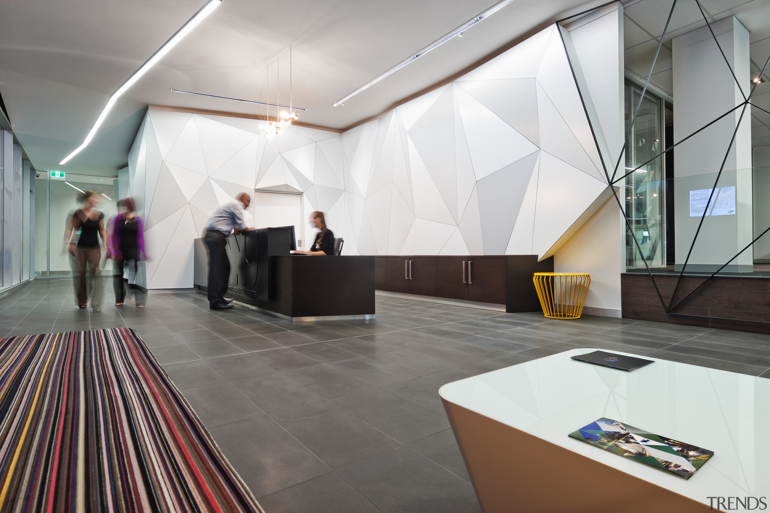 A multifaceted facade behind the reception desk of ceiling, design, exhibition, floor, flooring, interior design, product design, white, gray