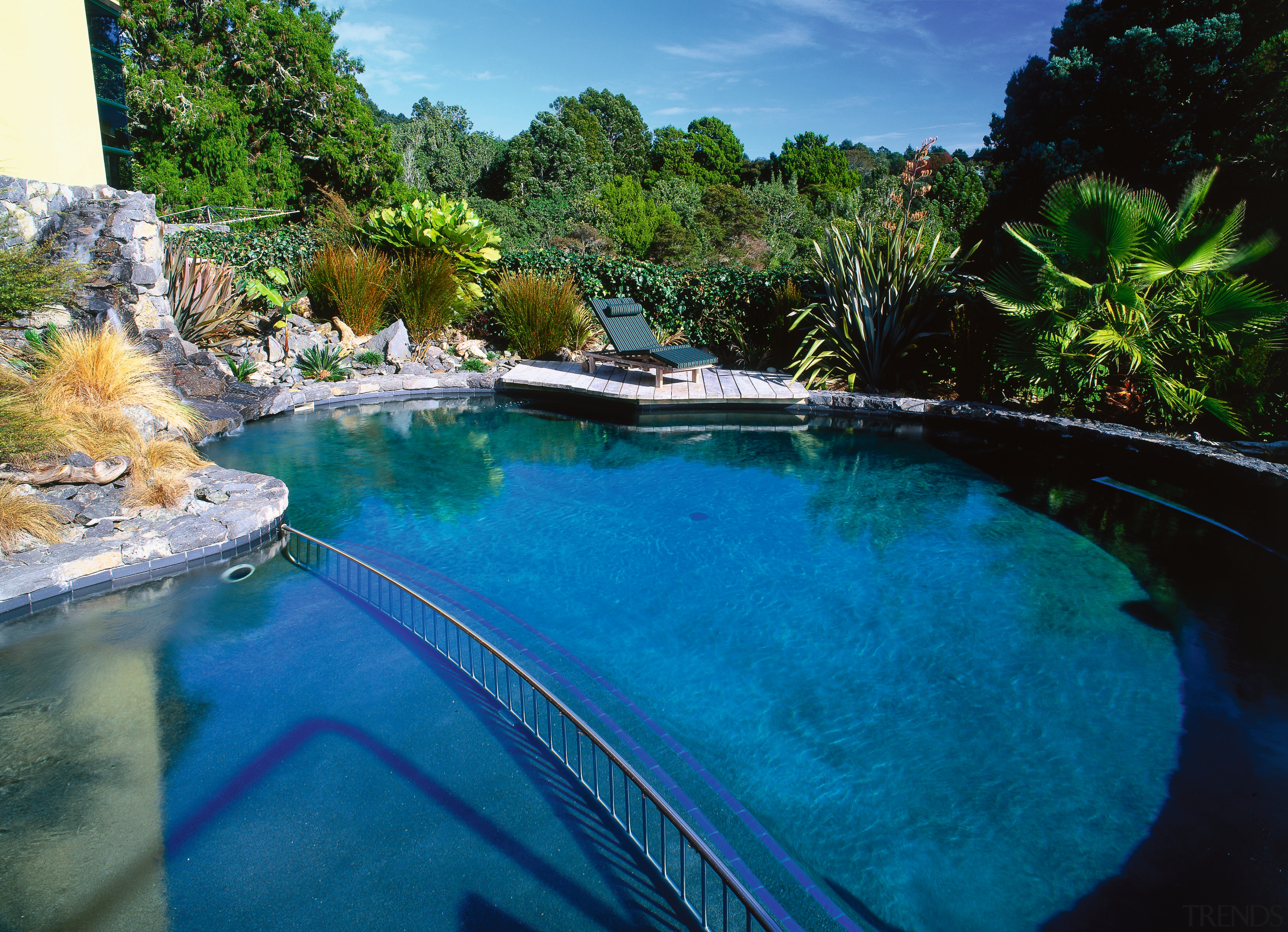 Round black pool in natural setting with stone leisure, pond, reflection, resort, swimming pool, tree, water, water feature, water resources, watercourse, blue