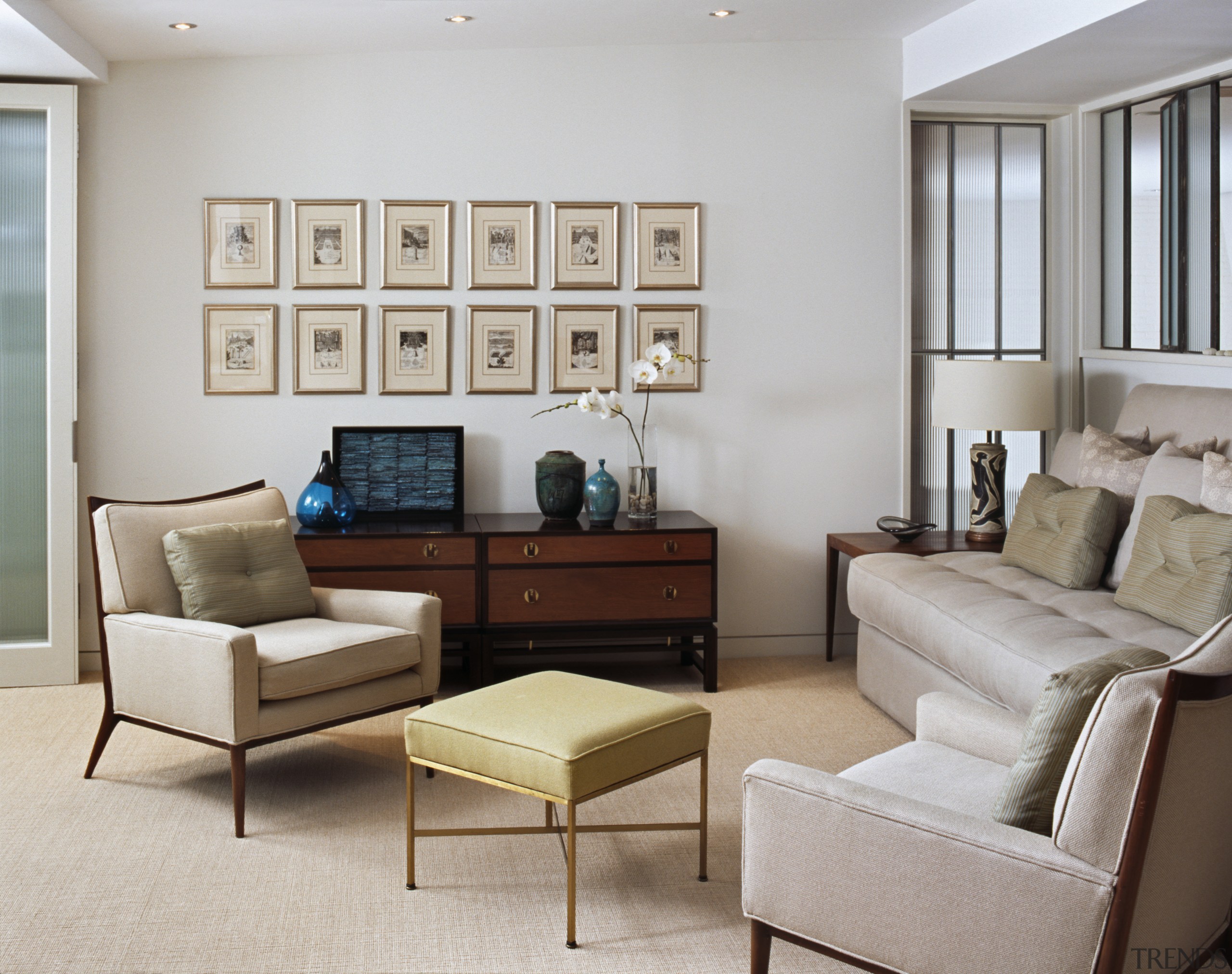 Many of the furnishings were collected by one couch, floor, furniture, home, interior design, living room, loveseat, room, table, wall, window, gray