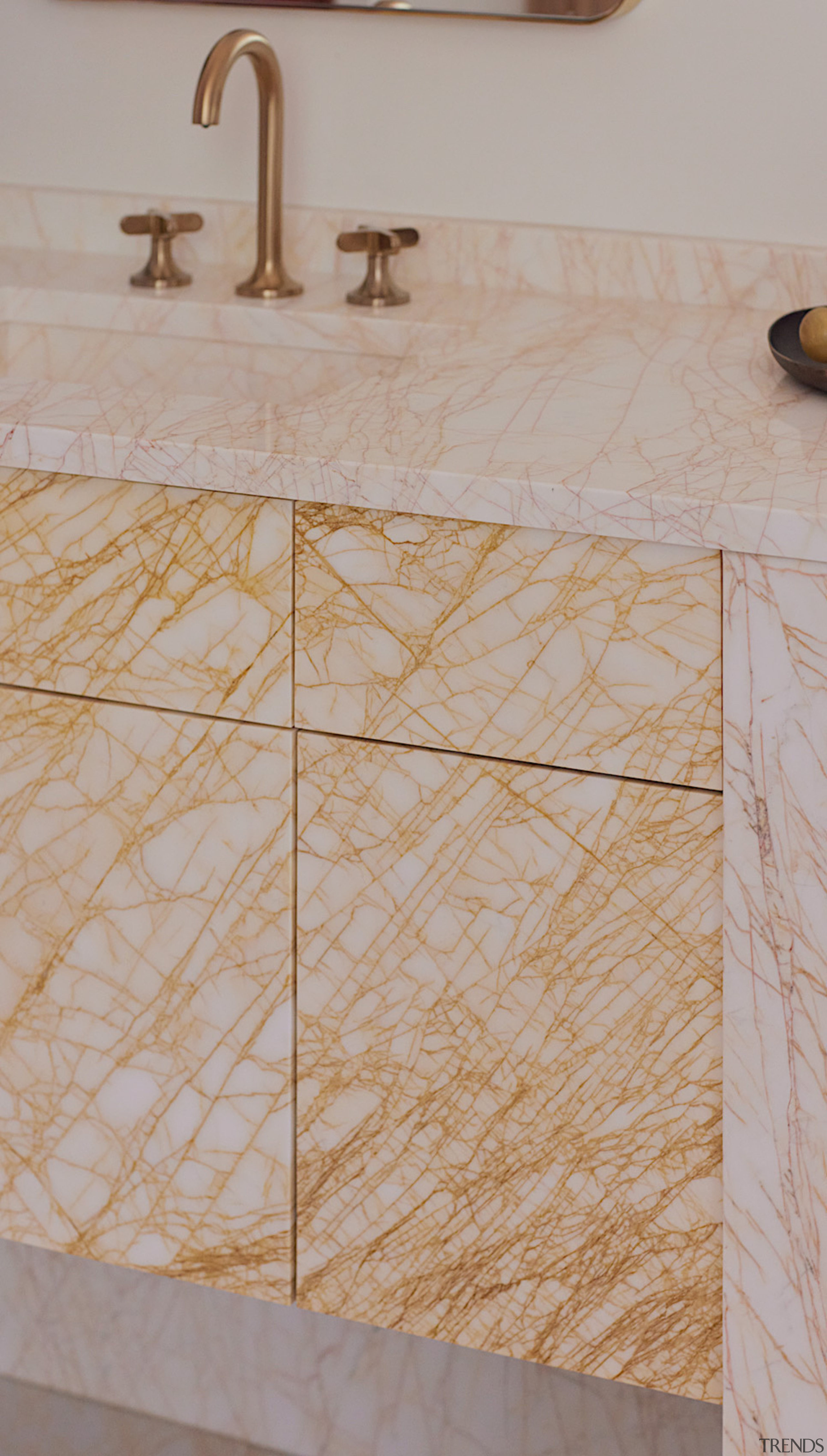 Vanity detail showing veined stone finish. - Gilded 