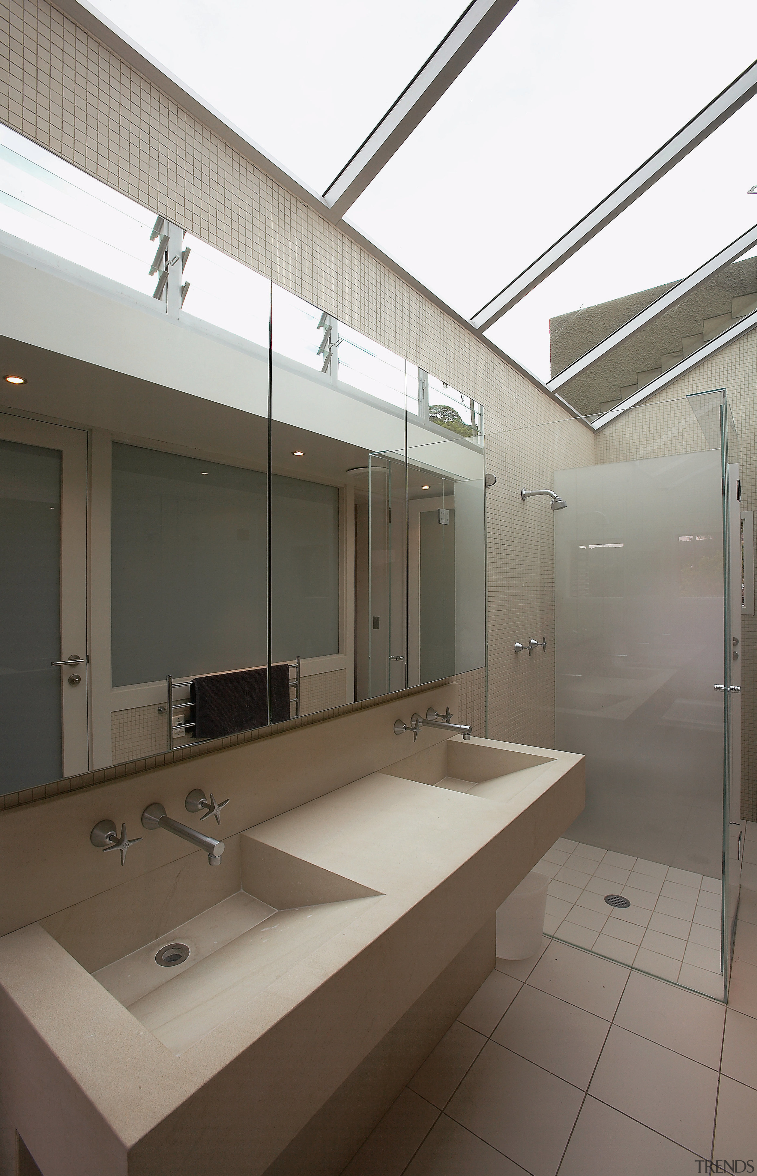 A view of the bathrom featuring tiled walls/flooring, architecture, bathroom, daylighting, glass, interior design, room, sink, gray