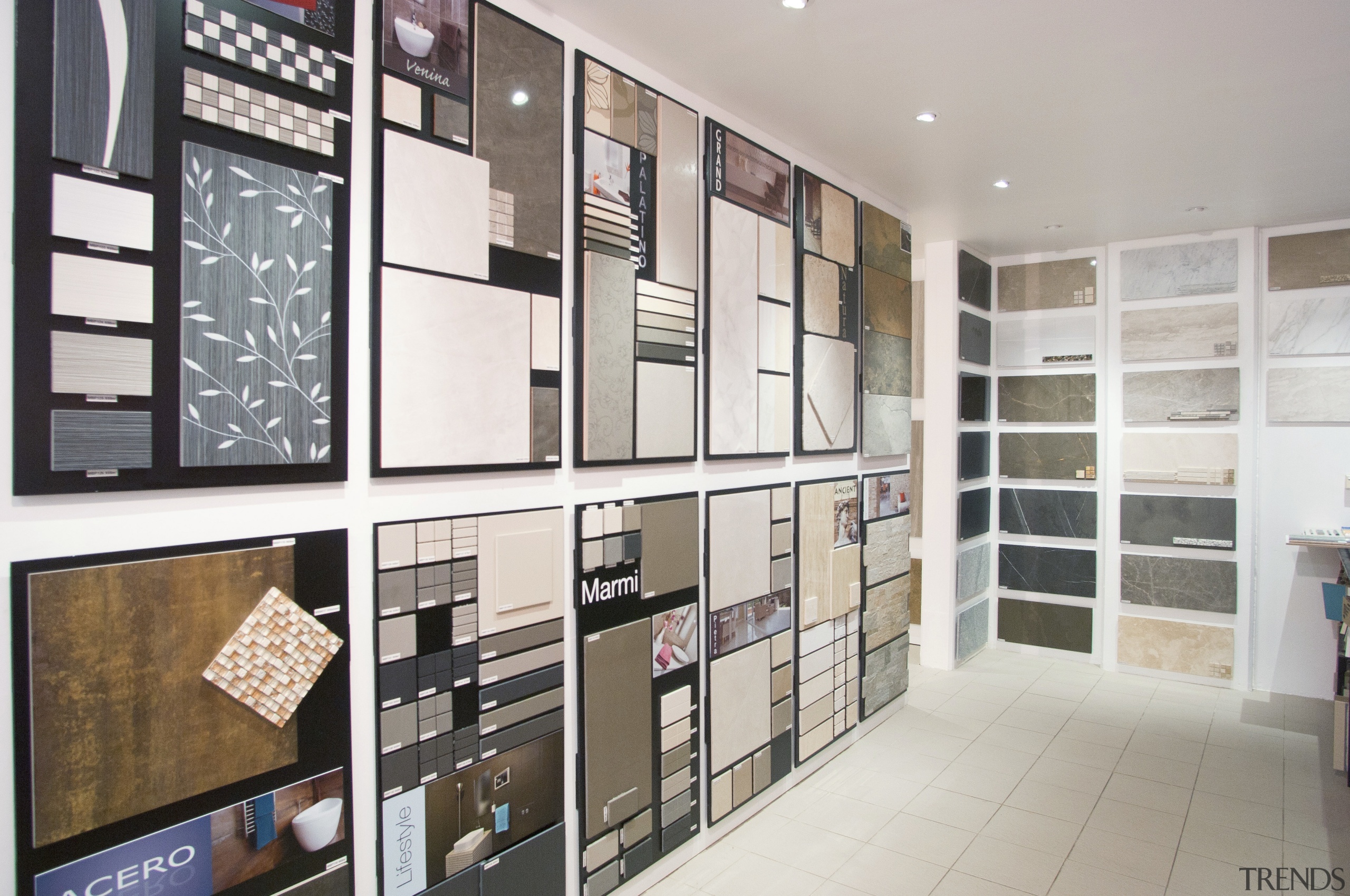 swatches of wallpaper, tiles, paint in showroom - bookcase, cabinetry, floor, furniture, interior design, shelf, shelving, white