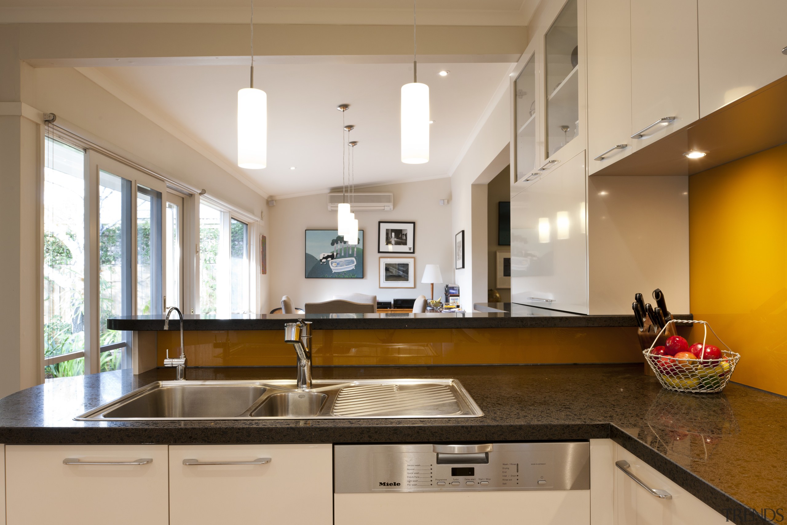 View of contemporary kitchen with white cabinetry, dark countertop, interior design, kitchen, real estate, room, brown, orange, white