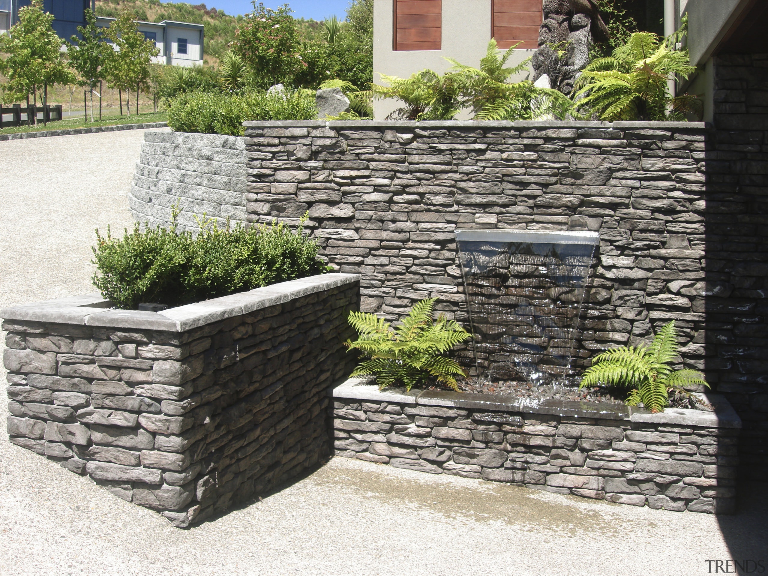 View of garden which includes a stone wall stone wall, walkway, wall, white