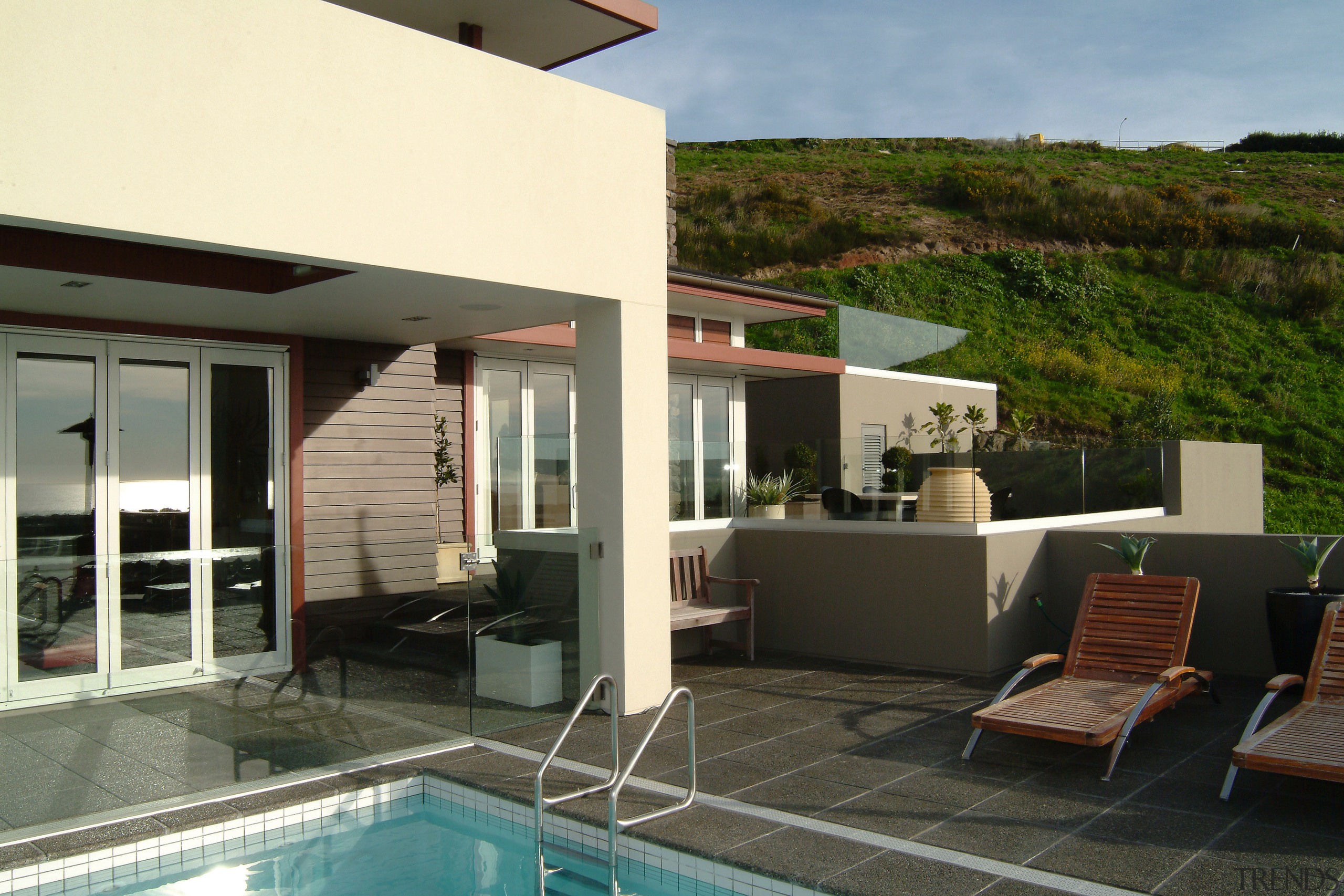 view of the outdoor pool area, with a home, house, property, real estate, villa, gray, black