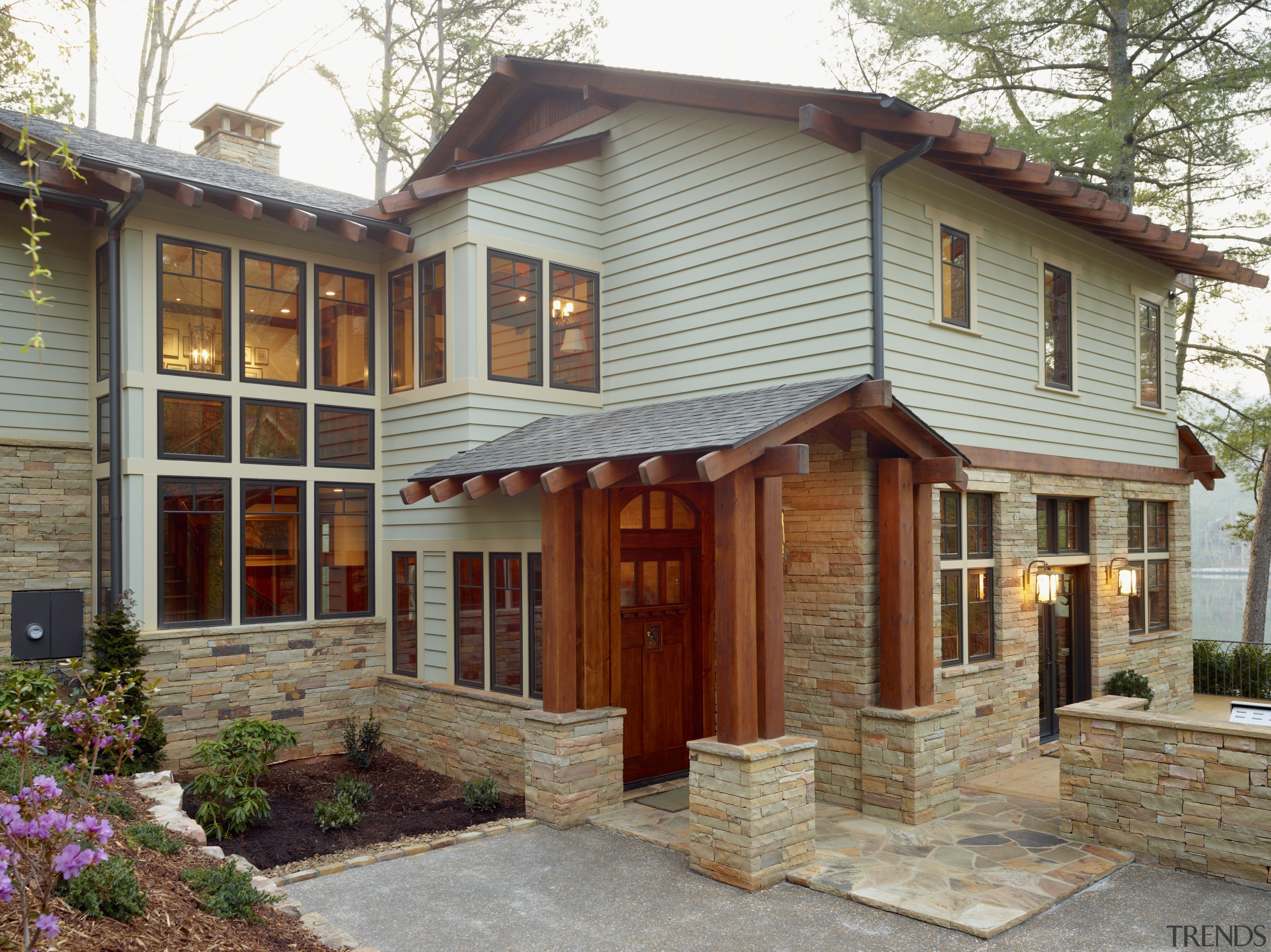 This lakefront house was remodeled to reference the cottage, elevation, estate, facade, home, house, outdoor structure, porch, property, real estate, siding, window, gray, brown