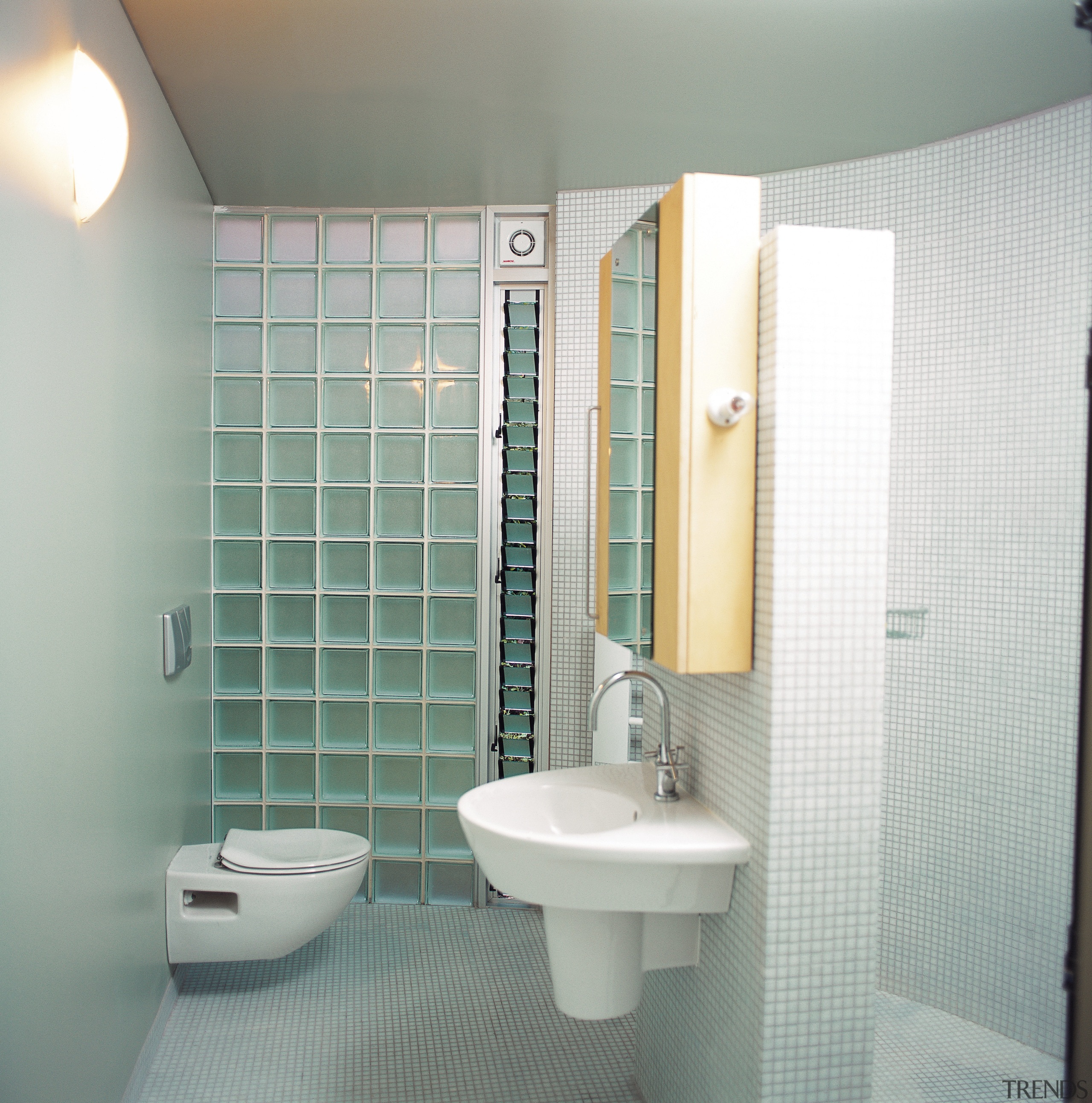 The view of a small bathroom featuring glass bathroom, bathroom accessory, bathroom cabinet, floor, interior design, plumbing fixture, room, tile, toilet, wall, gray