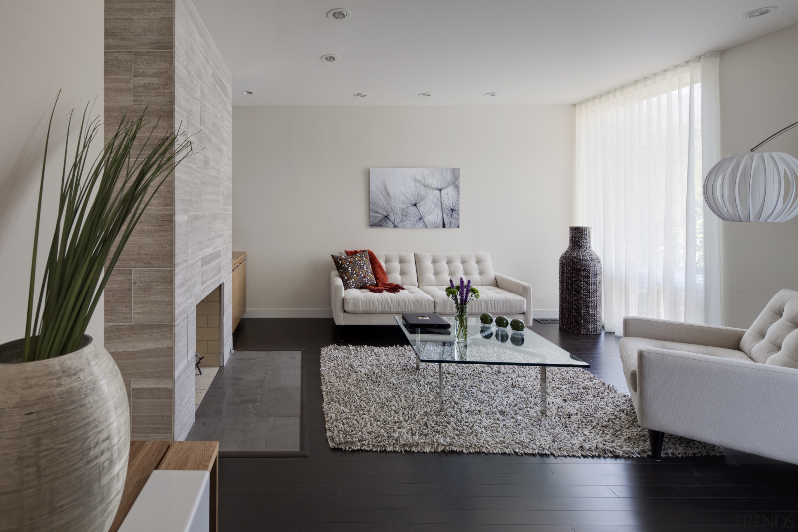 Lounge area with glass table and white couches. architecture, floor, flooring, home, house, interior design, interior designer, living room, real estate, room, table, wall, gray