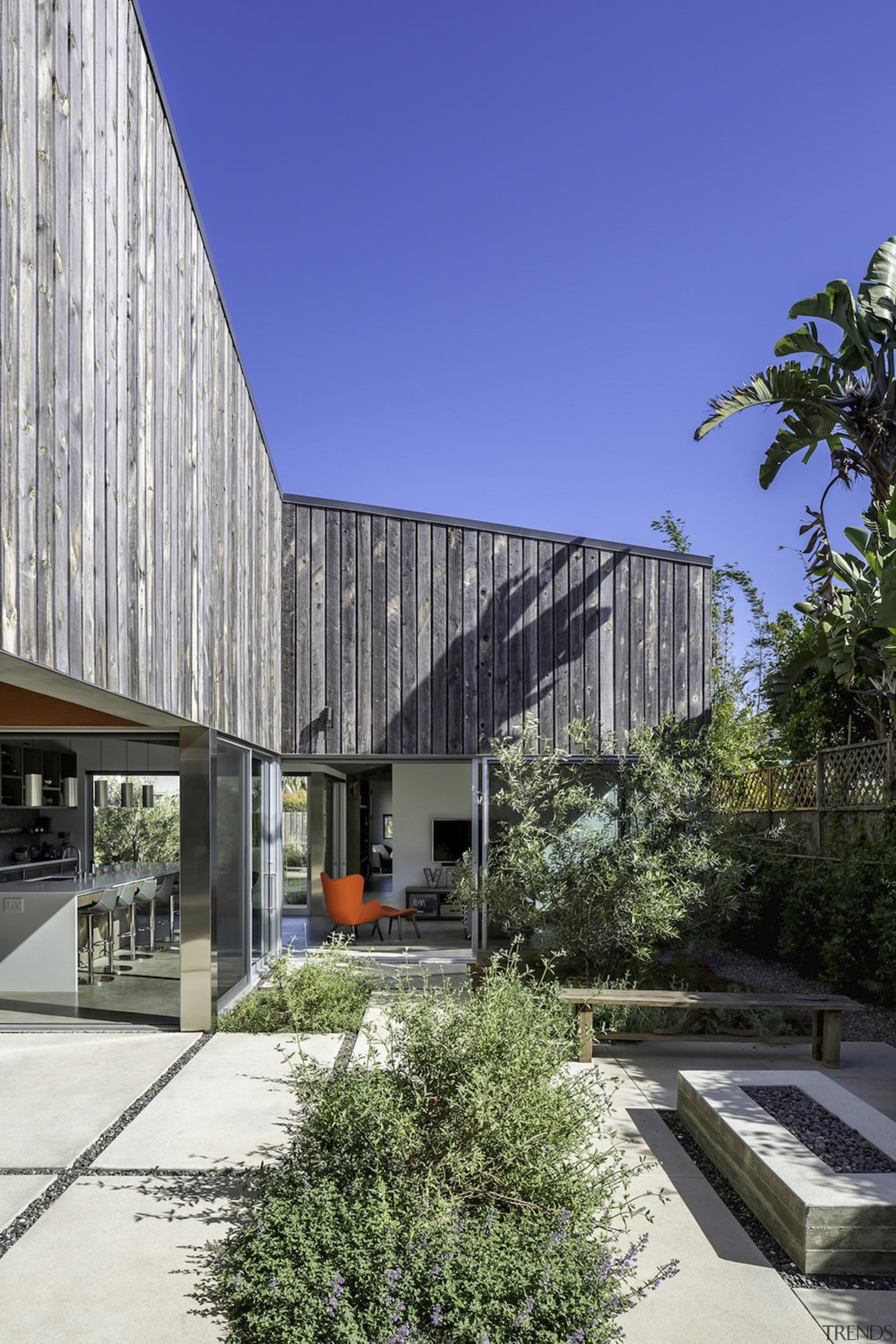 There's a clear connection between the courtyard and architecture, building, commercial building, condominium, corporate headquarters, facade, headquarters, house, mixed use, real estate, residential area, blue, gray