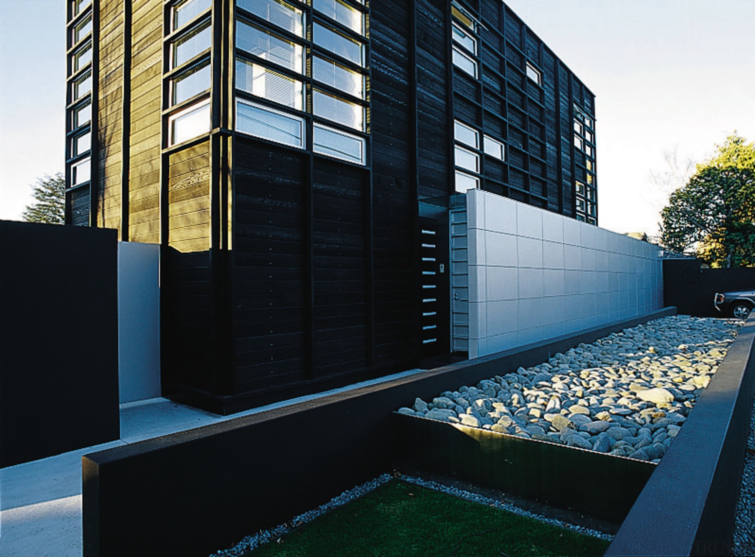 An exterior view of this contemporary home designed apartment, architecture, building, commercial building, condominium, corporate headquarters, facade, headquarters, home, house, reflection, residential area, window, black