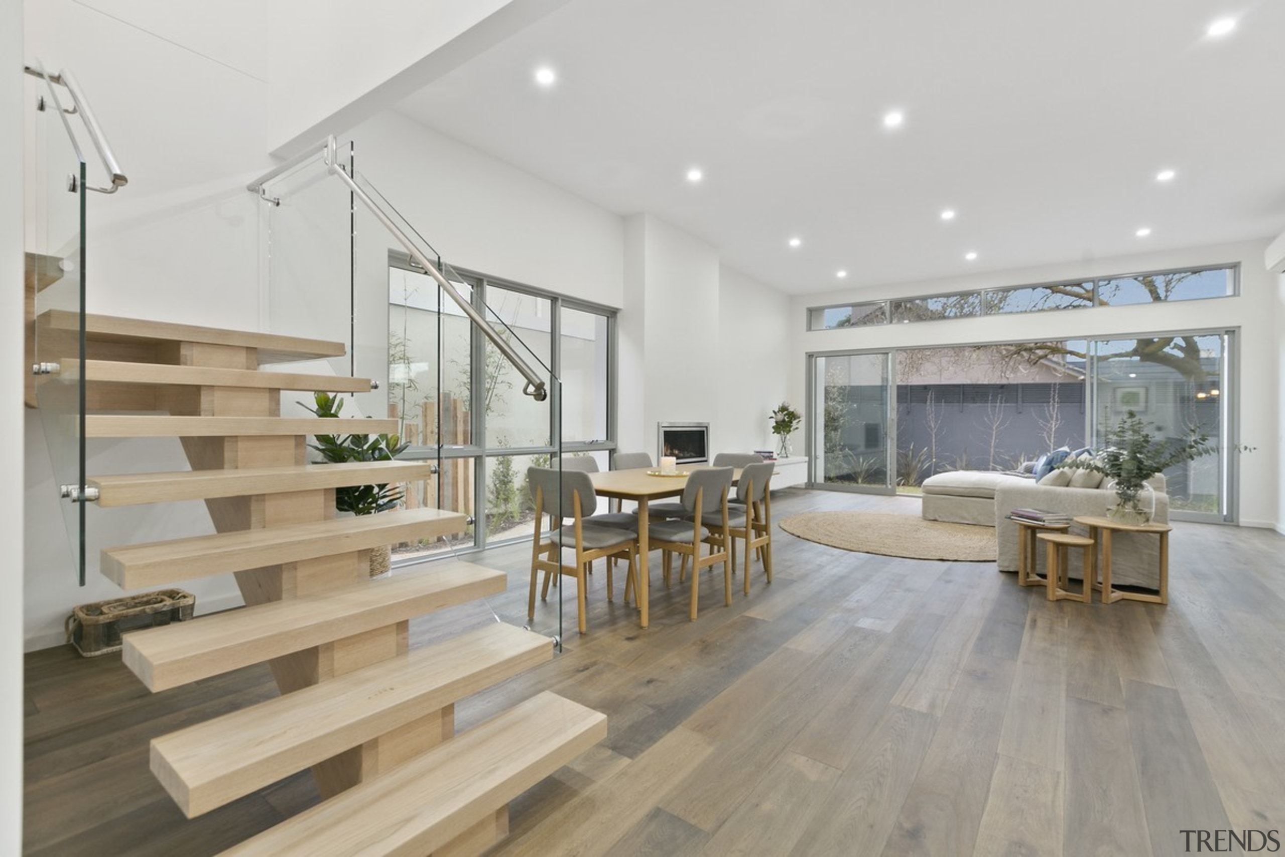 The glass balustrade sandwiches these floating wood steps floor, flooring, house, interior design, laminate flooring, living room, real estate, wood, wood flooring, gray