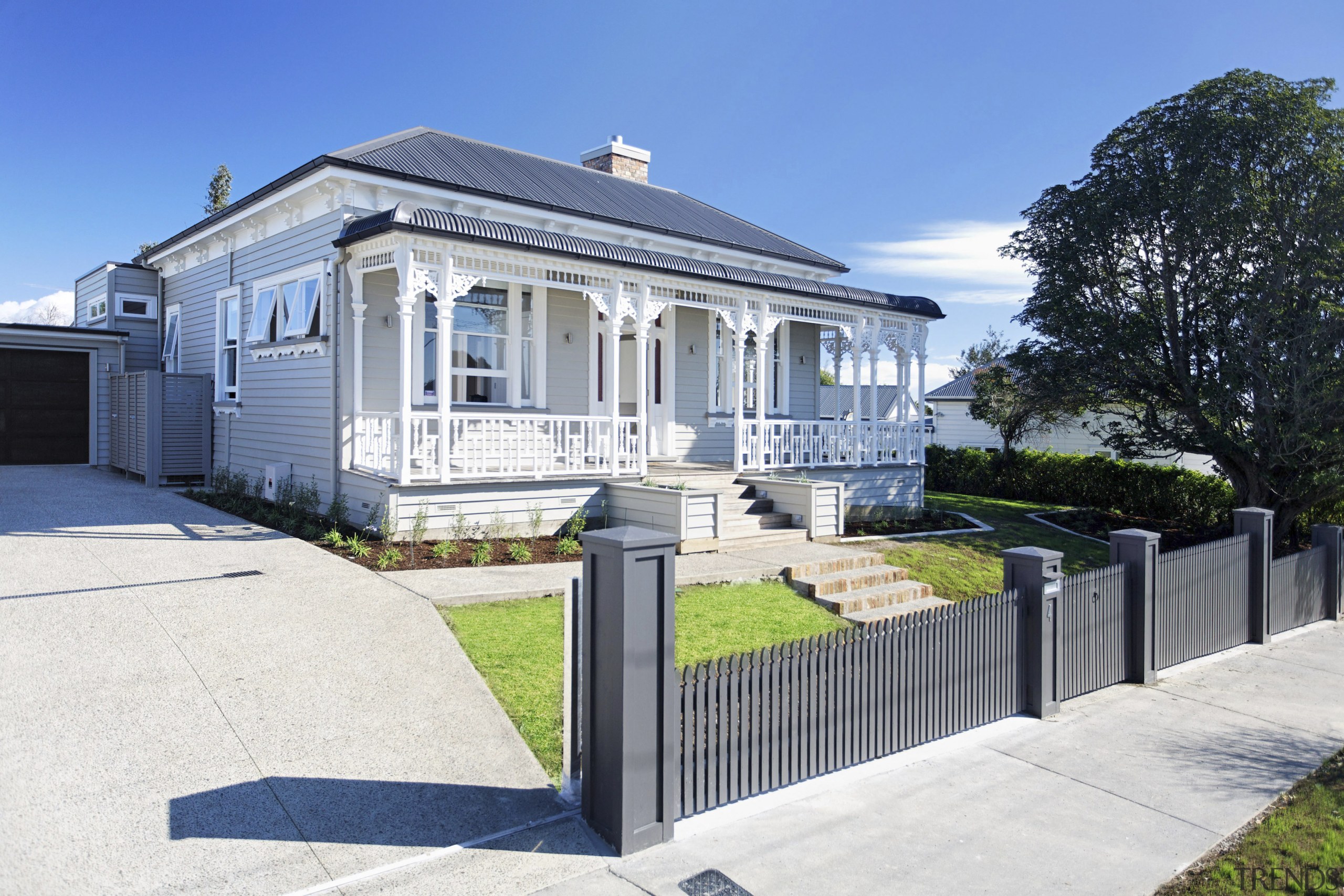 Exterior view of a villa-styled home which is cottage, estate, facade, fence, home, house, mansion, neighbourhood, property, real estate, residential area, villa, white, teal