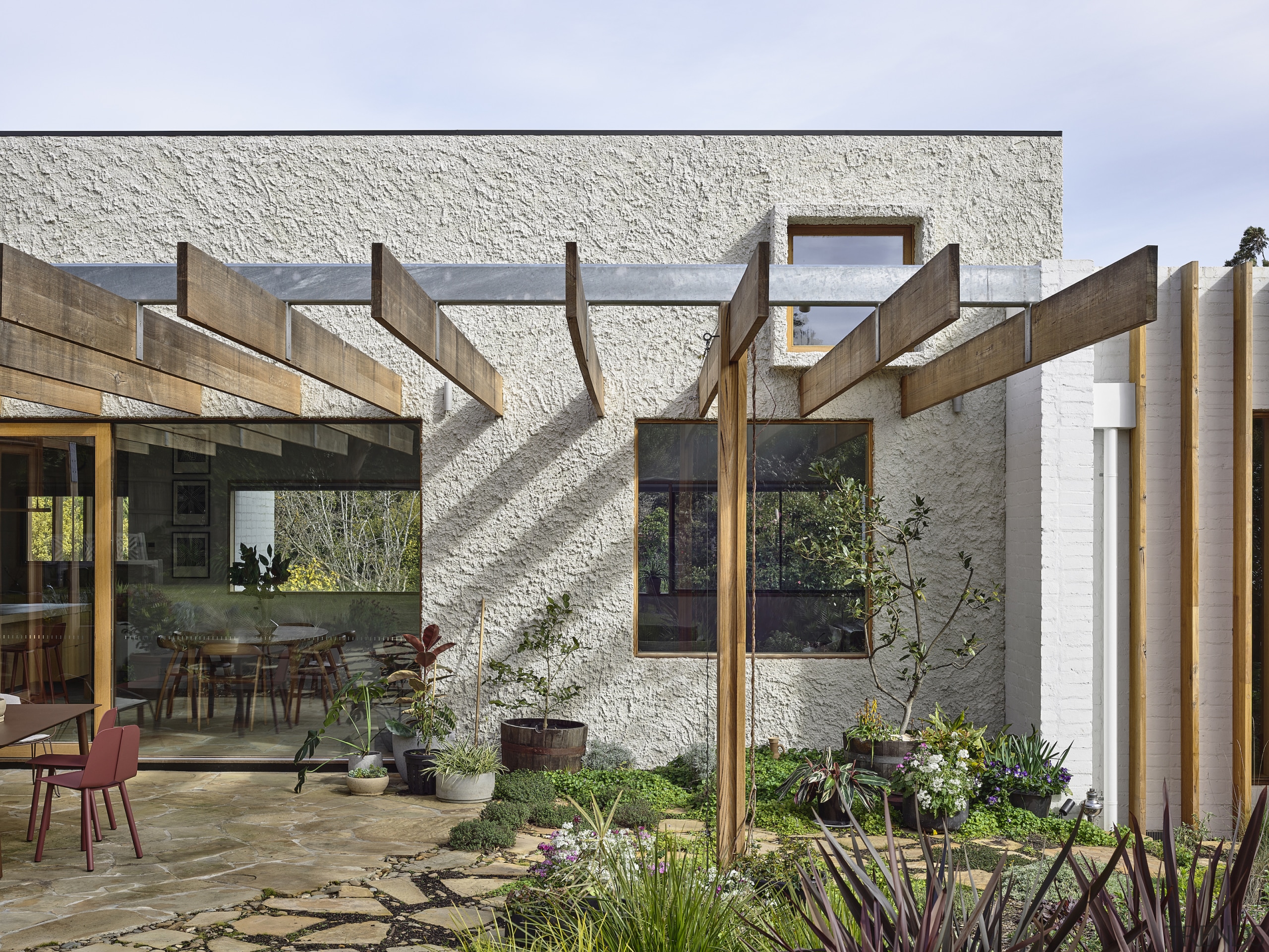 Victorian Ash timber beams of the pergola continue 