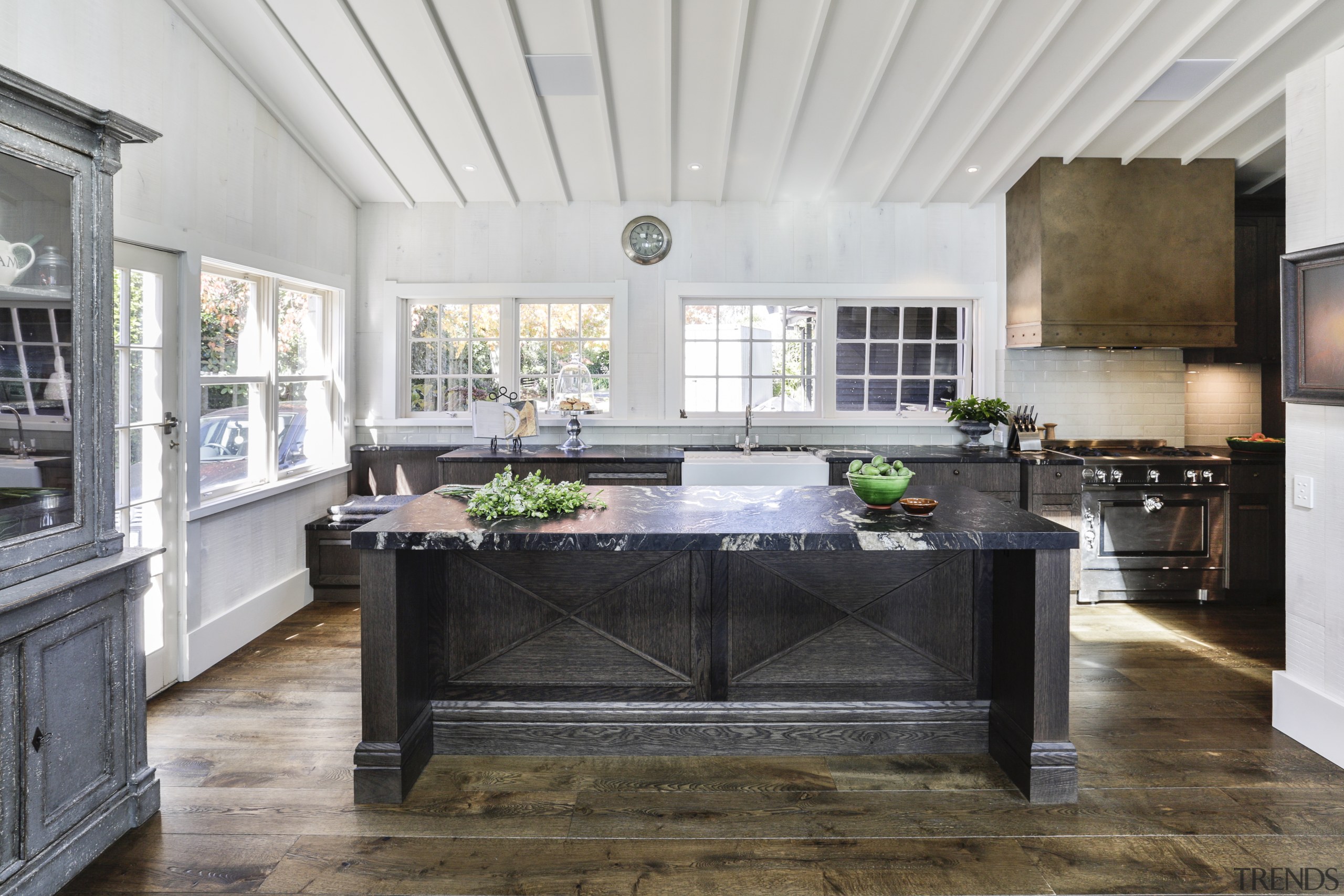 Elegant chocolate-stained oak cabinetry panelling and chunky leathered gray, white