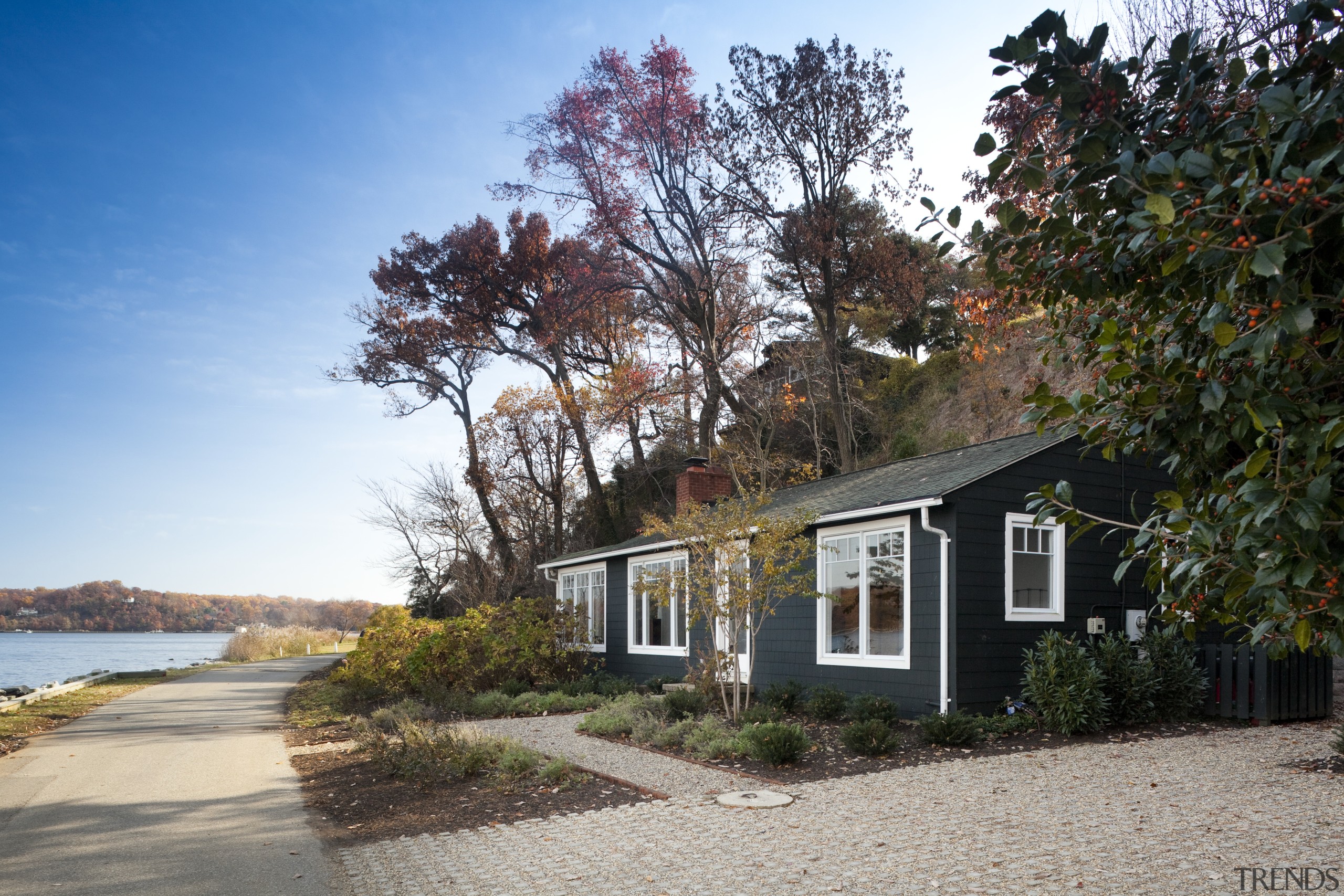 Grey house surrounded by tall trees next to autumn, cottage, estate, farmhouse, home, house, property, real estate, residential area, sky, tree