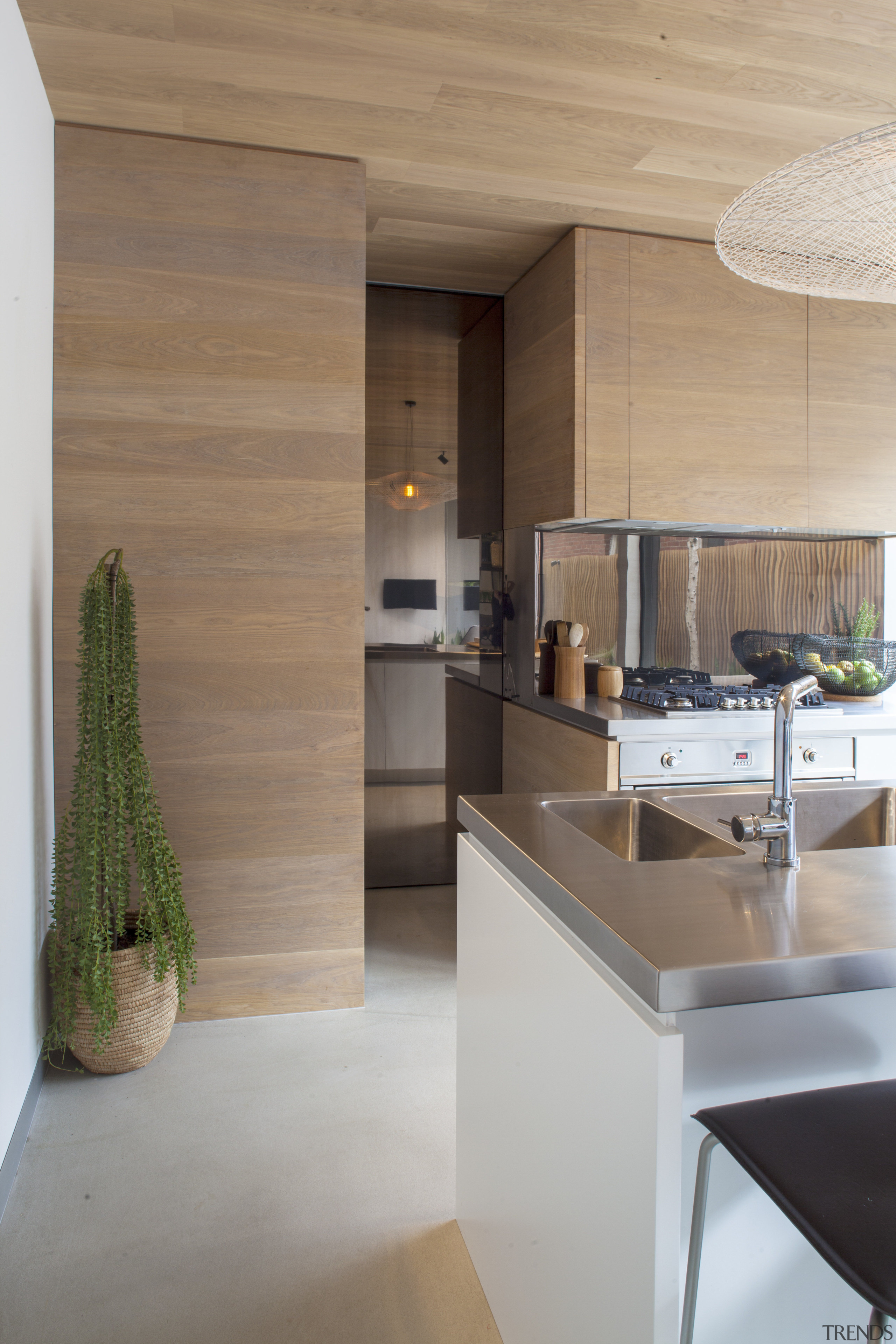 This kitchen's pantry is concealed behind a reflective architecture, countertop, floor, flooring, house, interior design, kitchen, wood, gray, brown