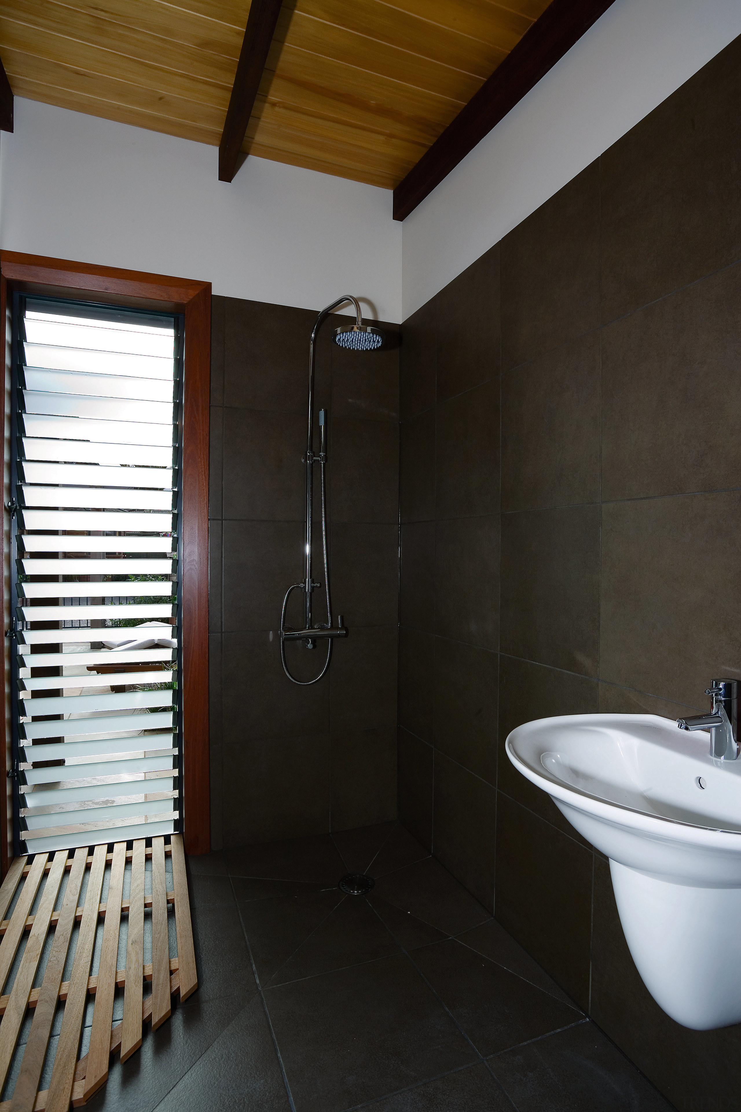 A view of the pool house shower and architecture, bathroom, ceiling, daylighting, floor, home, house, interior design, property, room, tile, wall, black