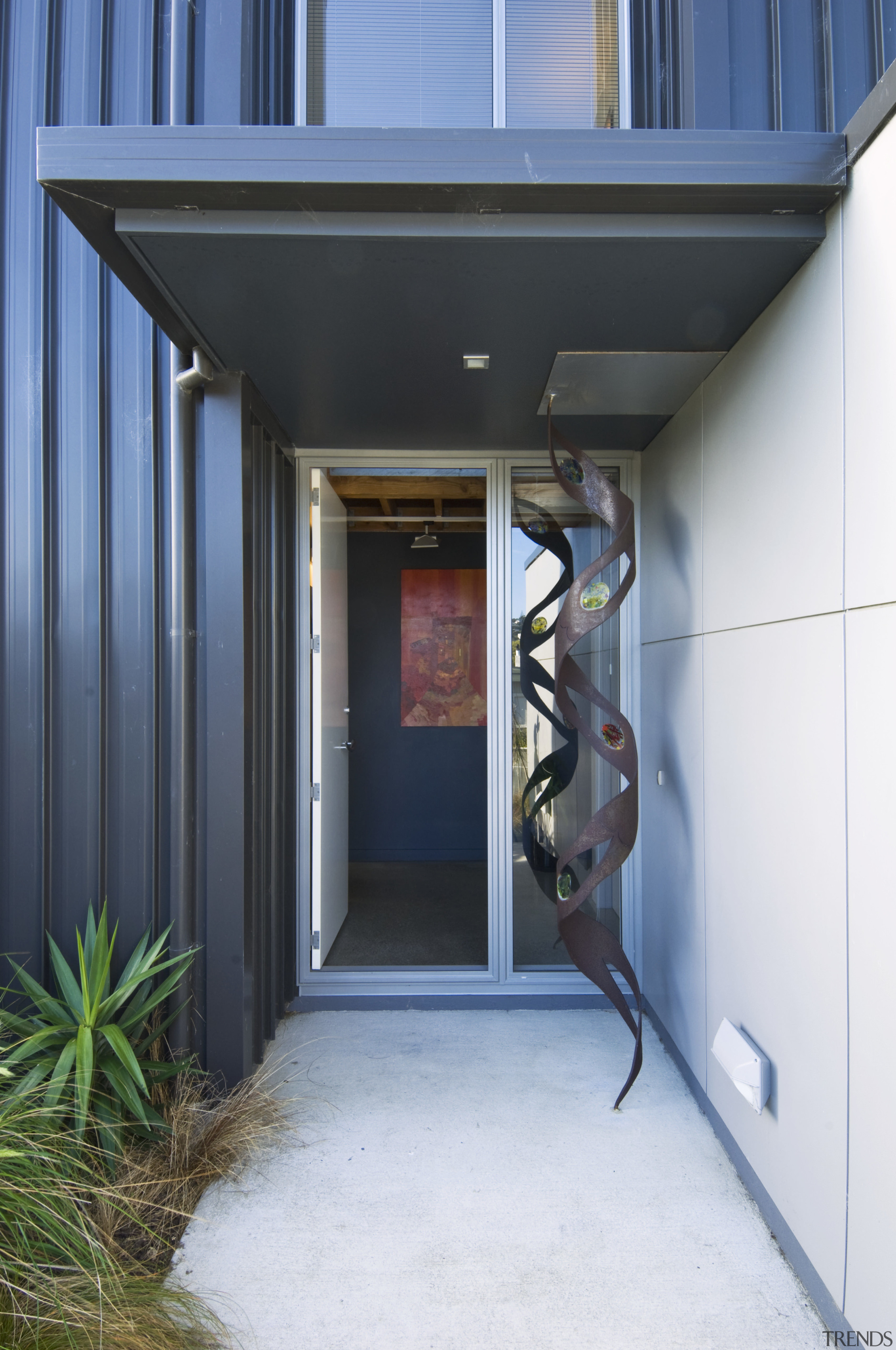 Exterior view of entrance way featuring landscaping, glazing, architecture, door, home, house, real estate, black, white