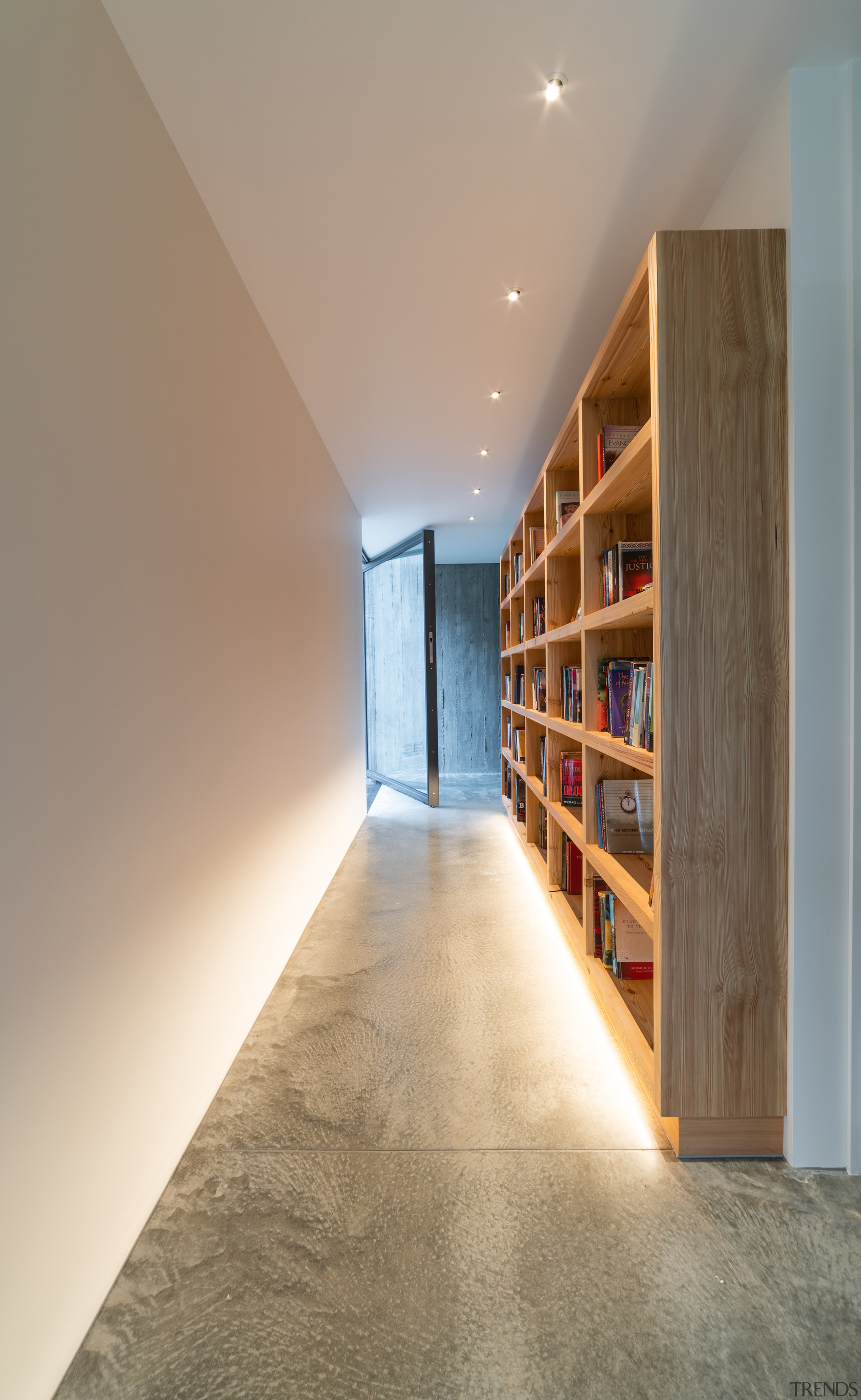 A gallery-style hallway defined by a concrete floor 