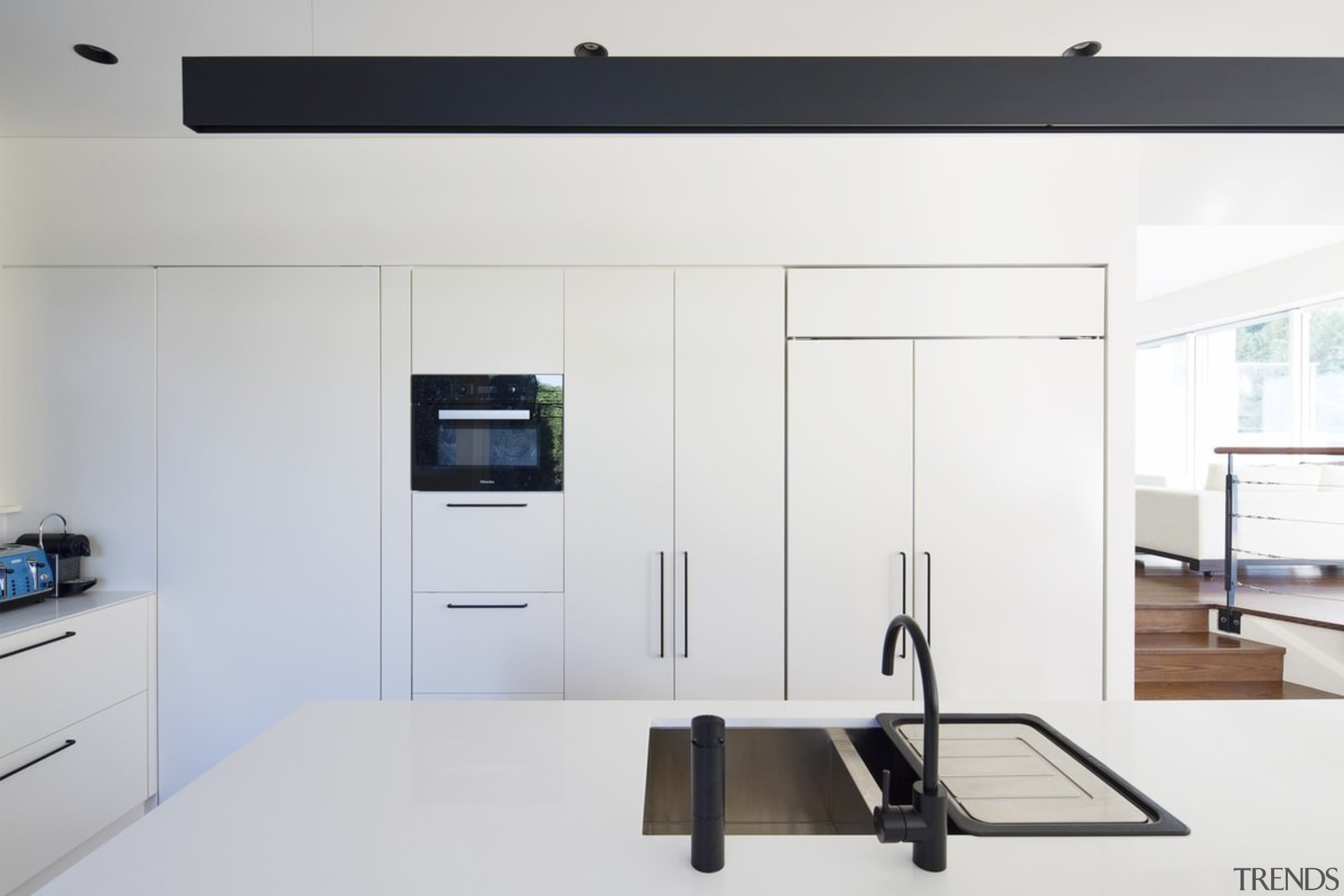 This kitchen features black tapware, which stands out home appliance, interior design, product design, white, gray
