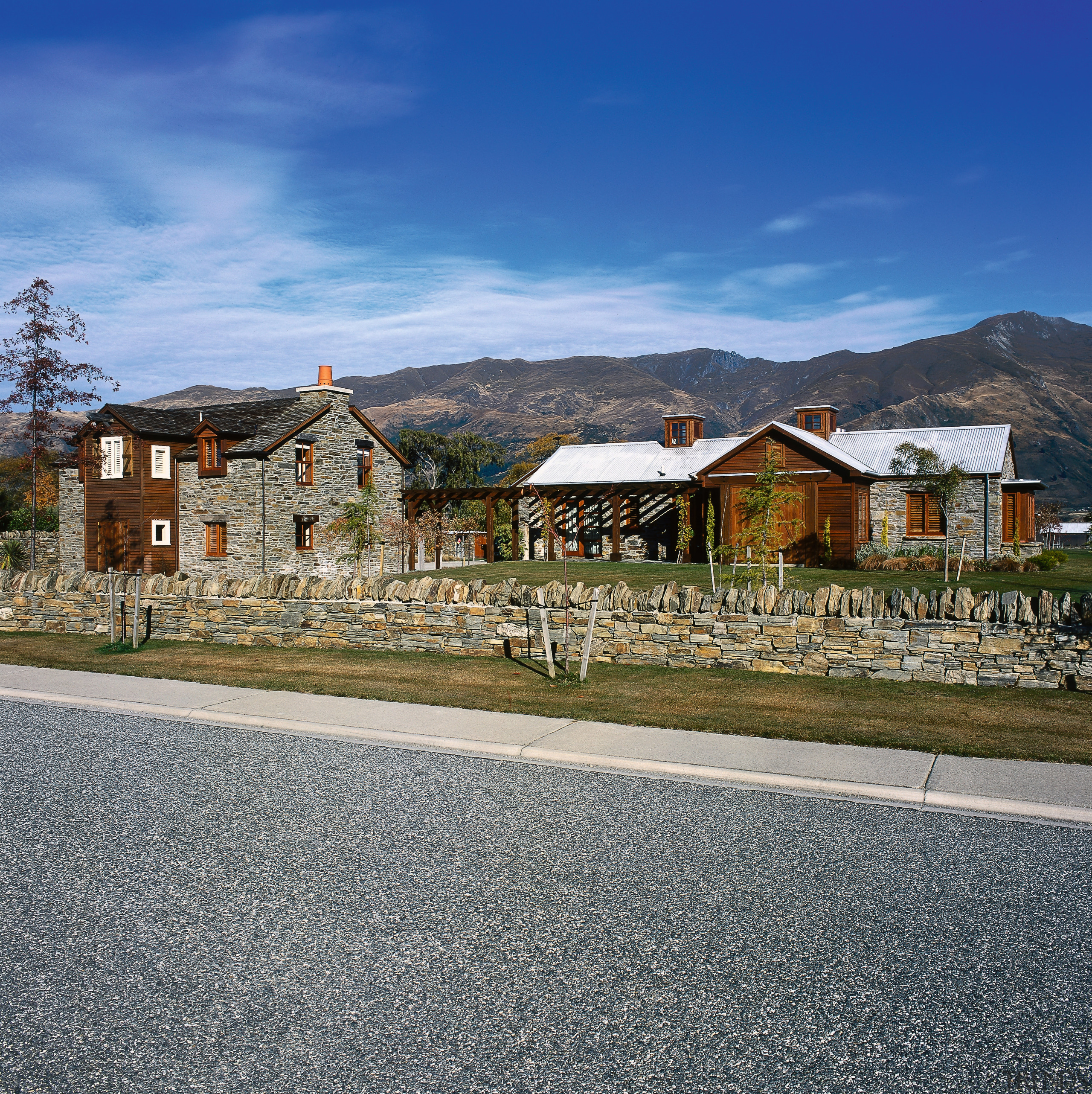 An exterior view of the entire house, wooden alps, city, cloud, cottage, estate, home, house, mountain, mountain range, neighbourhood, real estate, residential area, road, sky, suburb, town, tree, village, blue