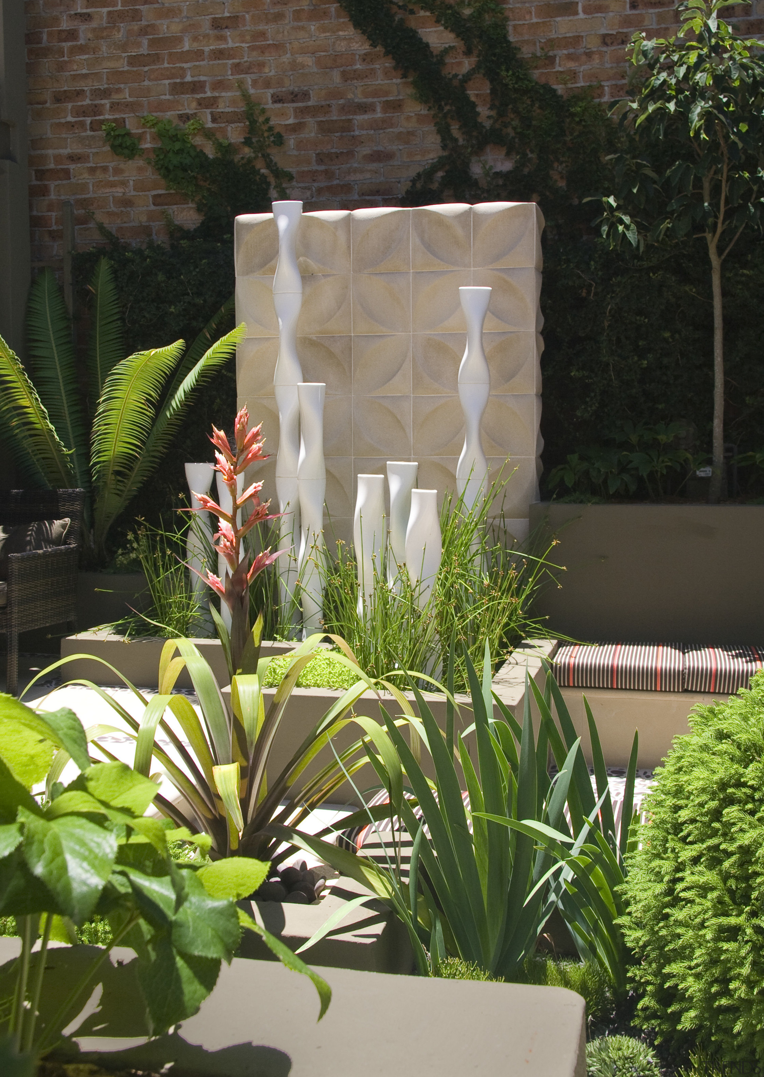 View of outdoor living area and courtyard featuring arecales, flora, floristry, flower, flowerpot, garden, landscaping, outdoor structure, plant, brown, green