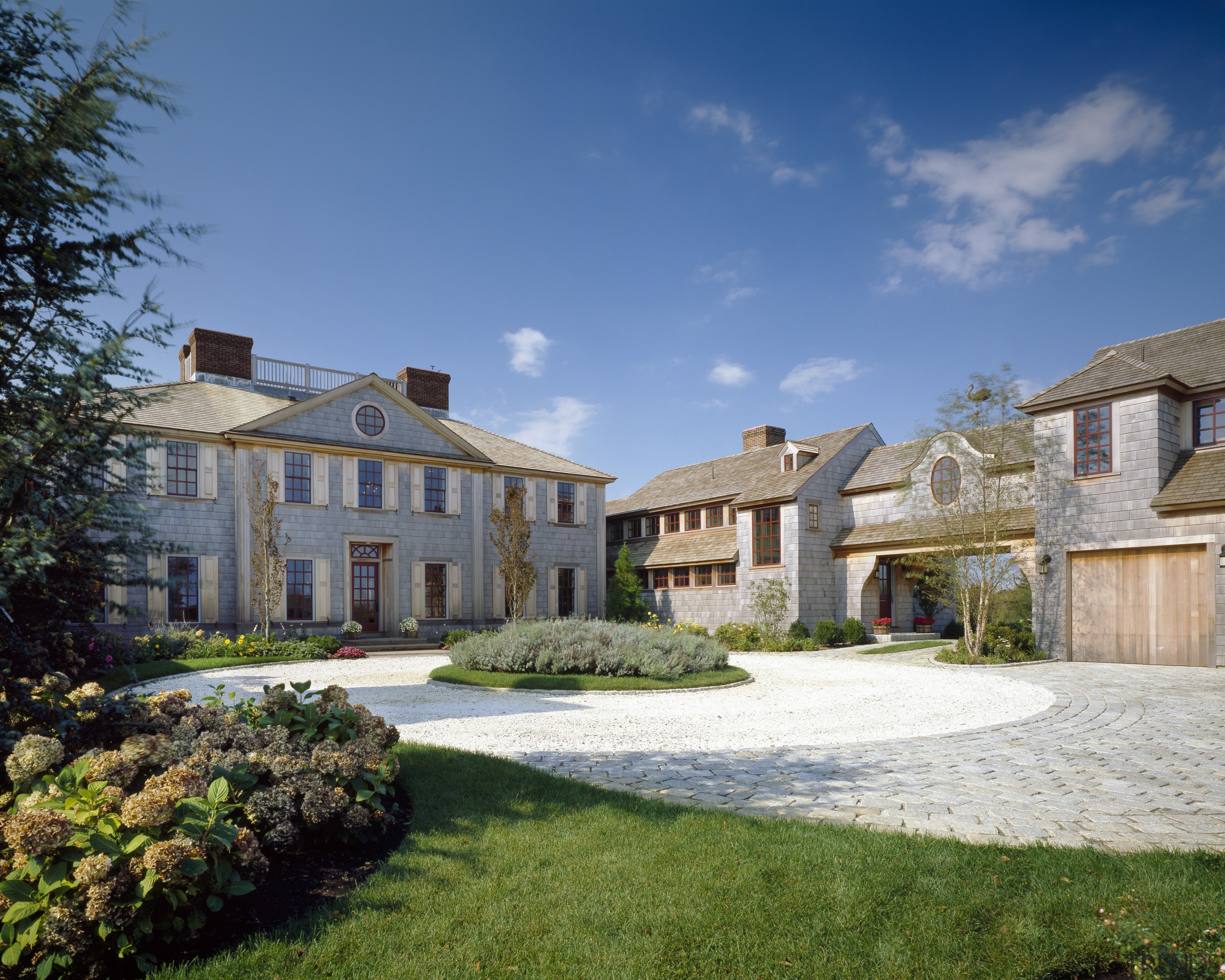 Exterior view of a large cottage with cedar cottage, estate, facade, farmhouse, home, house, landscaping, mansion, neighbourhood, property, real estate, residential area, sky, suburb, villa, teal