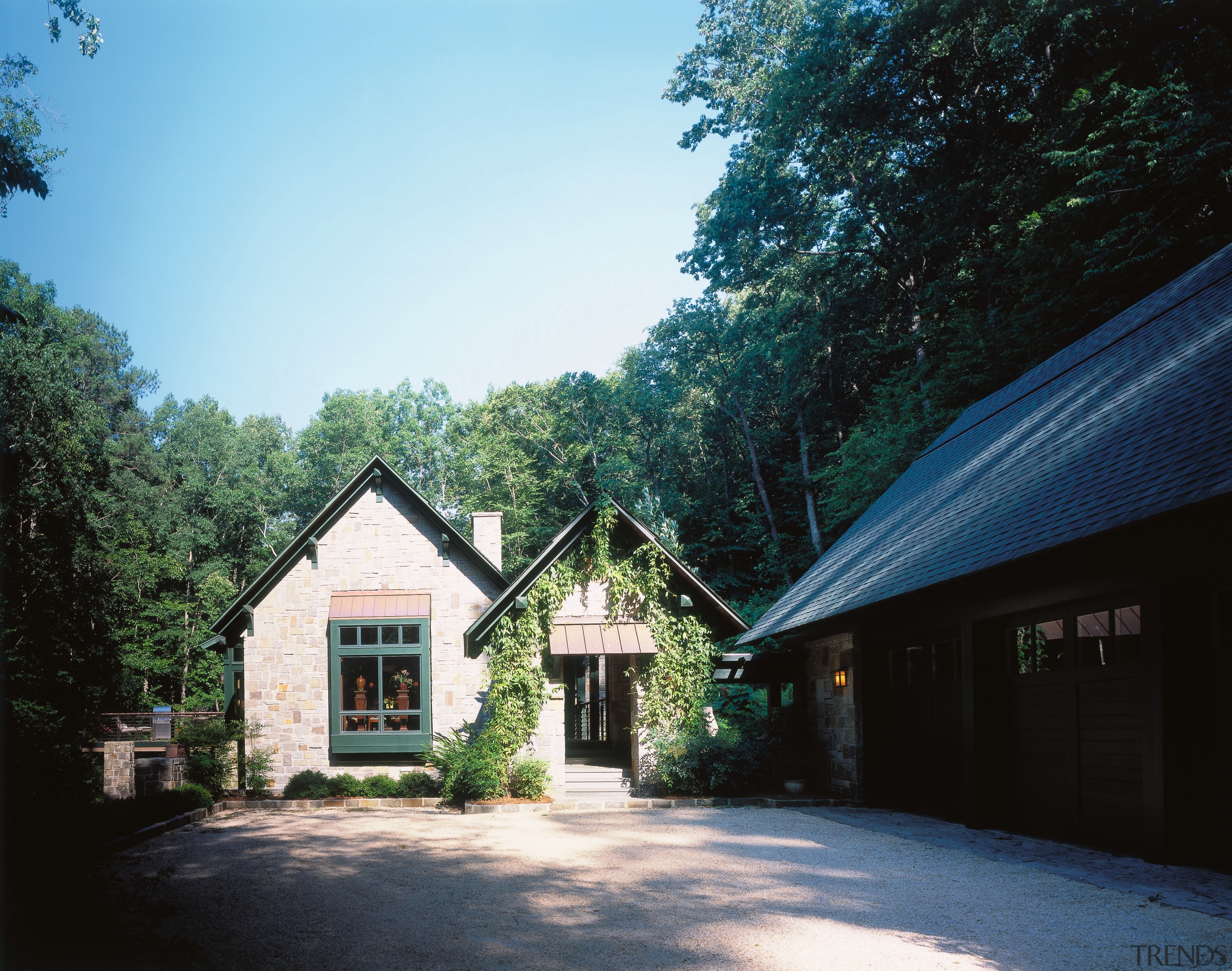 exterior view of this home nestled amogst the cottage, estate, facade, farmhouse, home, house, landscape, property, real estate, residential area, roof, sky, tree, black