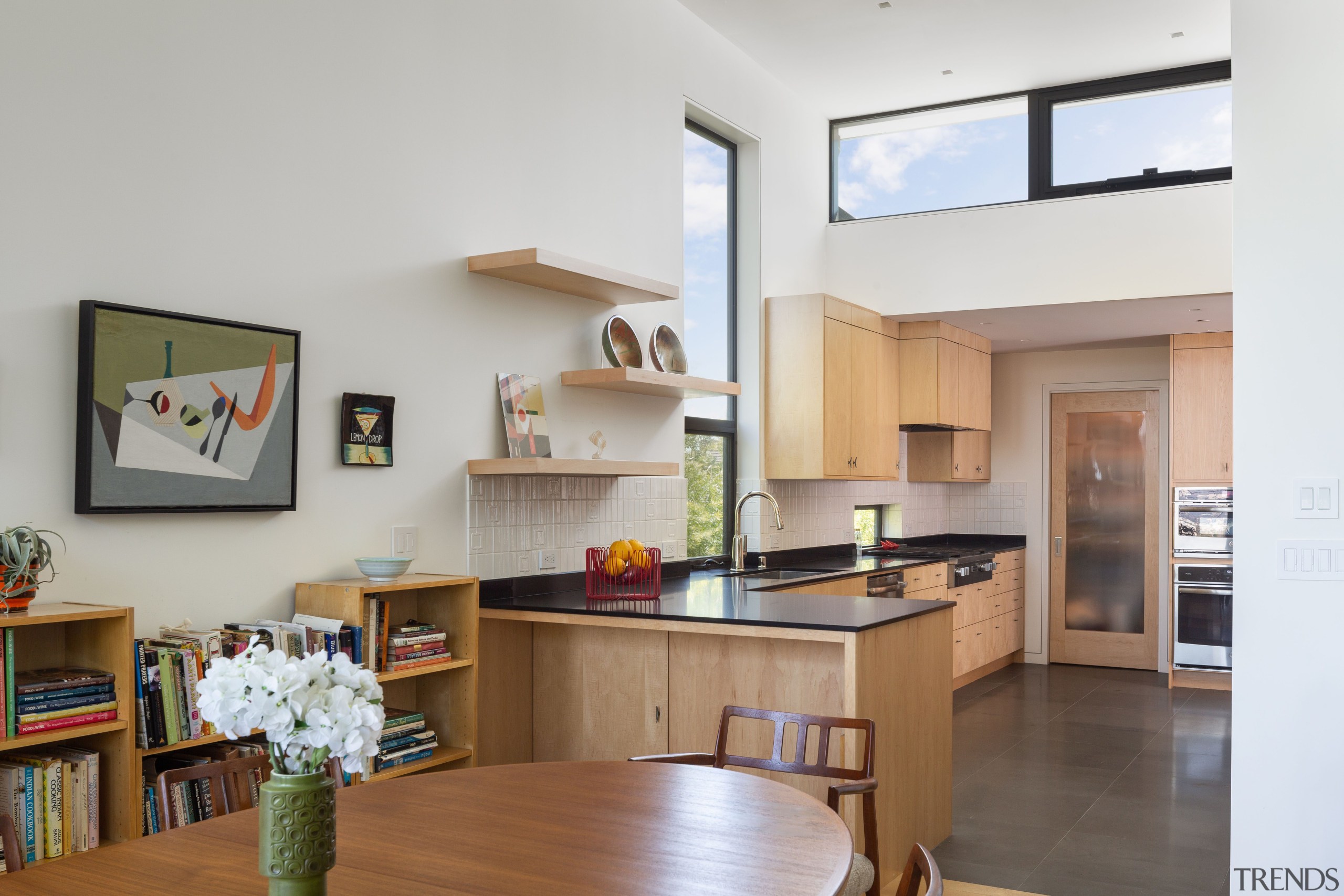 The kitchen features custom-design integrated shelving, incorporating ample 