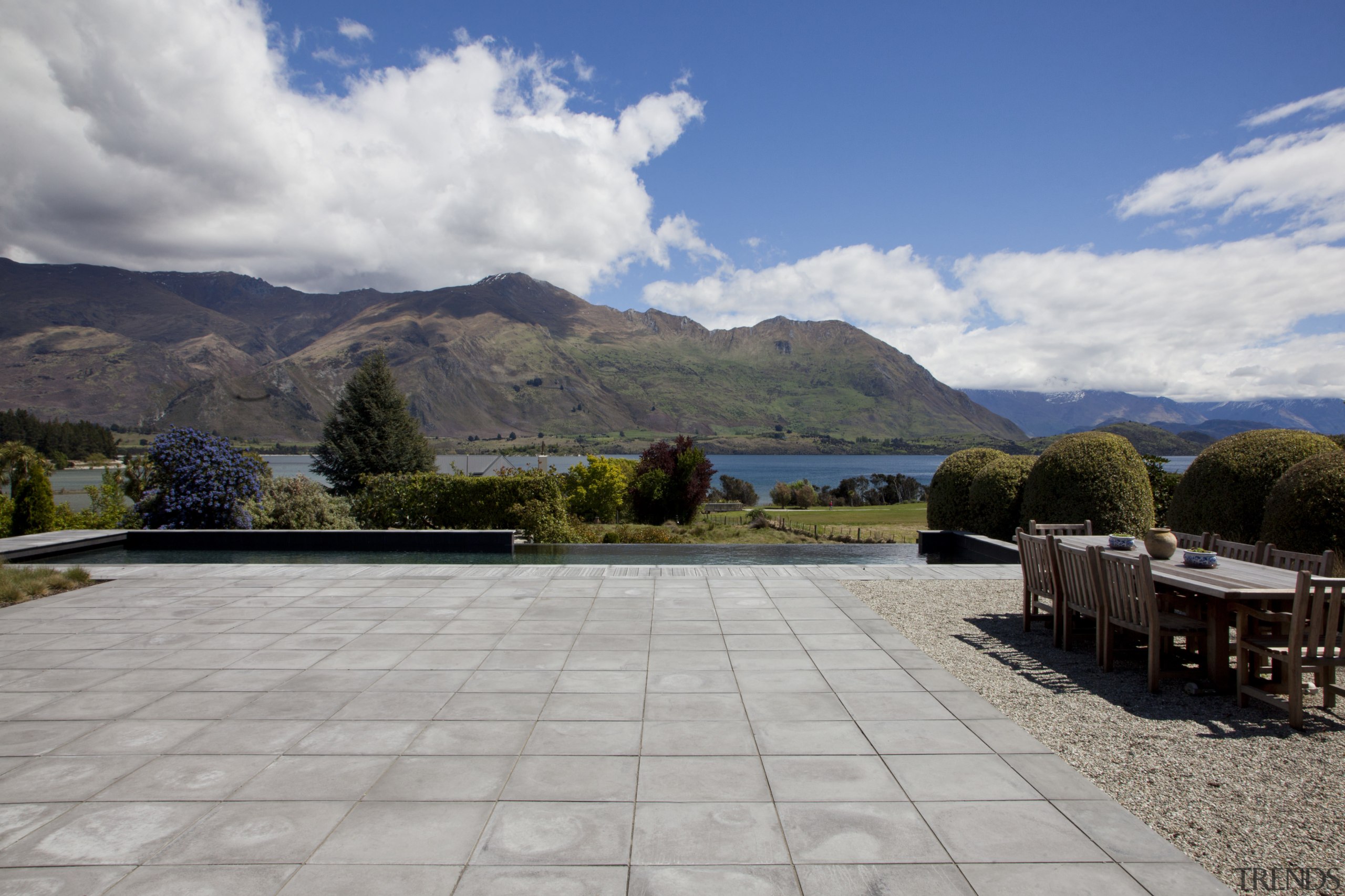 View of outdoor patio area with table and cloud, estate, home, landscape, mountain, plant, property, real estate, roof, sky, tree, gray