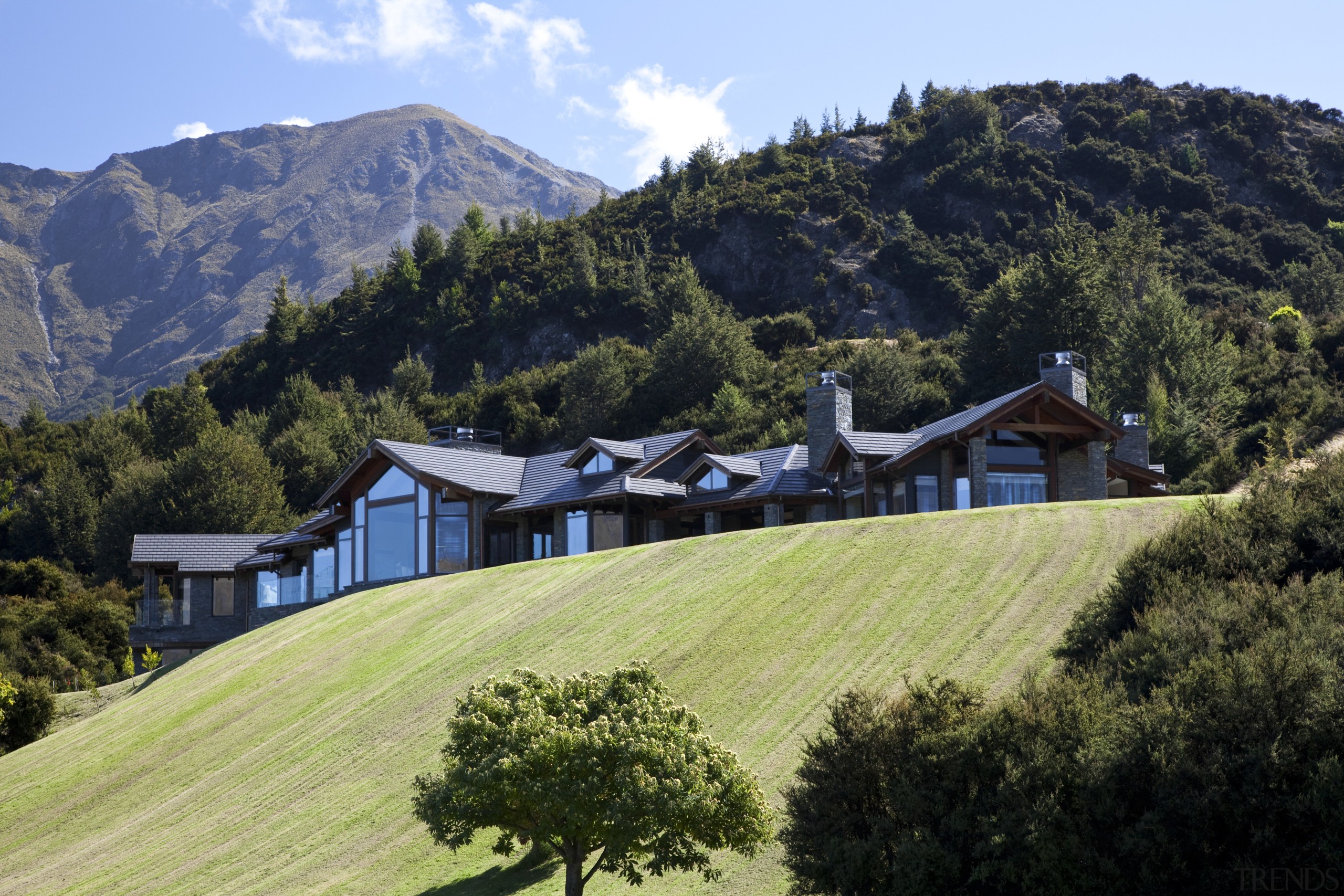 View of contemporary home on hilltop. - View alps, cottage, estate, farm, field, grass, grassland, highland, hill, hill station, home, house, hut, landscape, mount scenery, mountain, mountain range, mountain village, mountainous landforms, property, real estate, roof, rural area, sky, tree