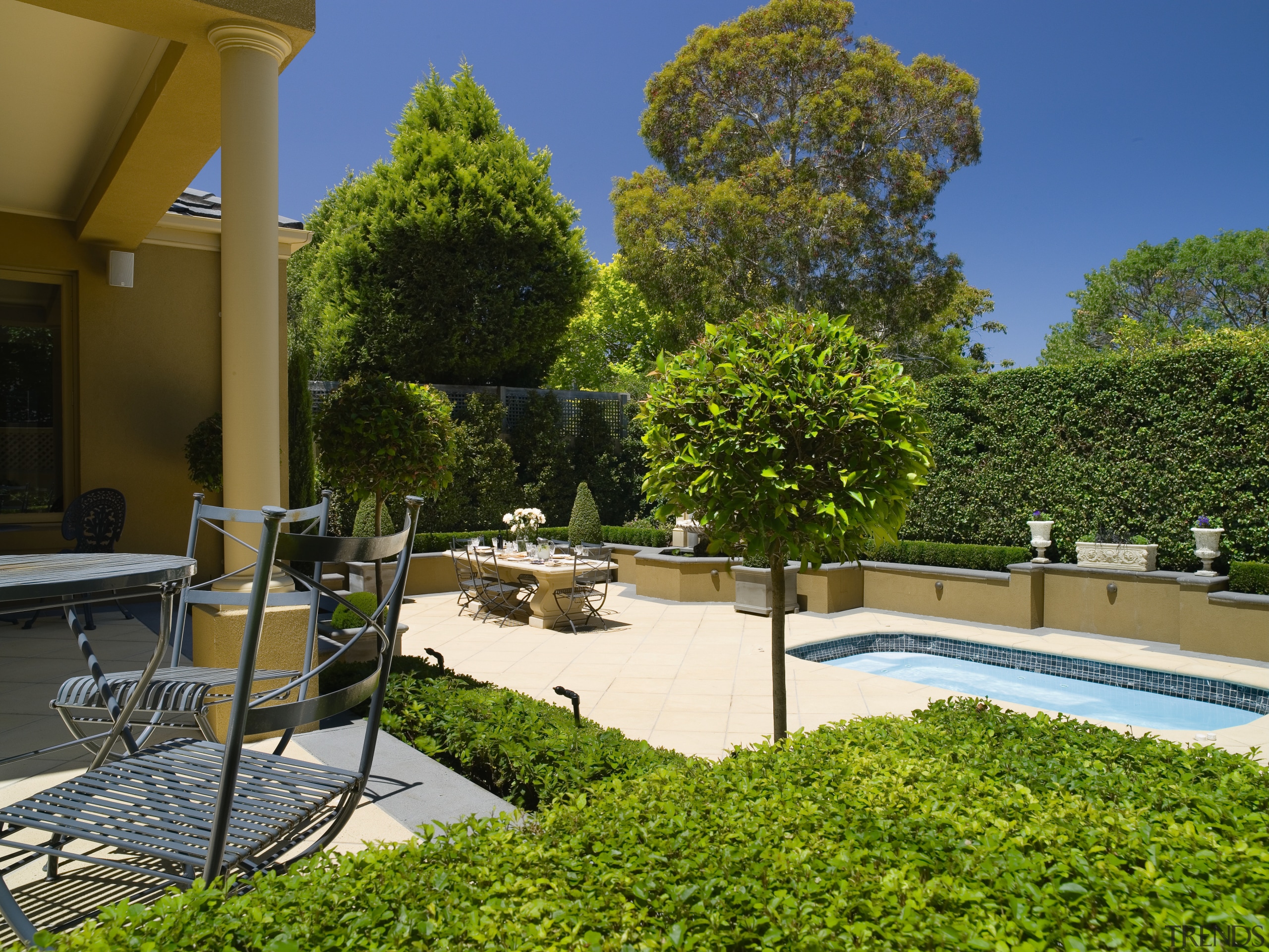 A view of this  Mediteranean style house backyard, courtyard, estate, garden, home, house, landscaping, outdoor structure, plant, property, real estate, tree, brown