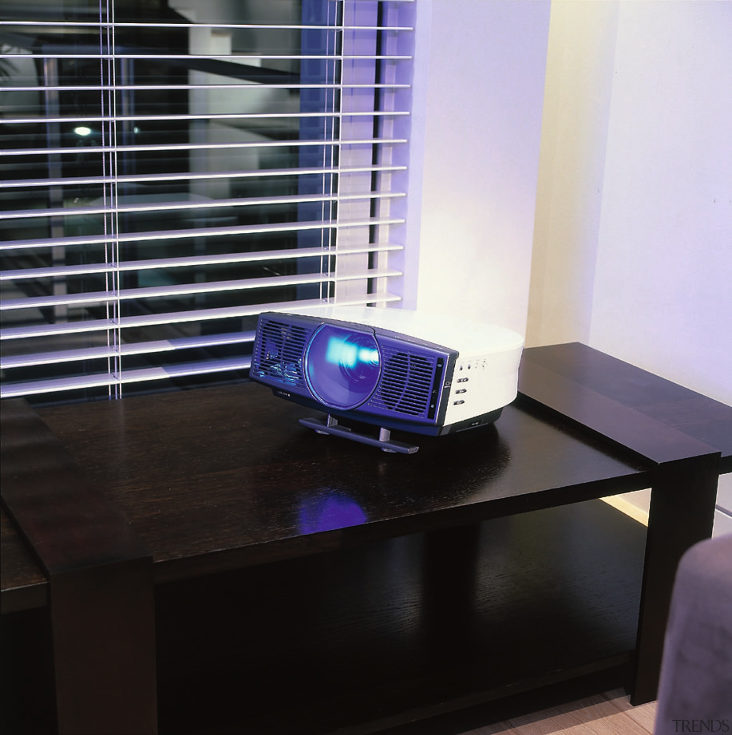 A photograph of a Cineza home theatre projector furniture, glass, product design, table, black, white