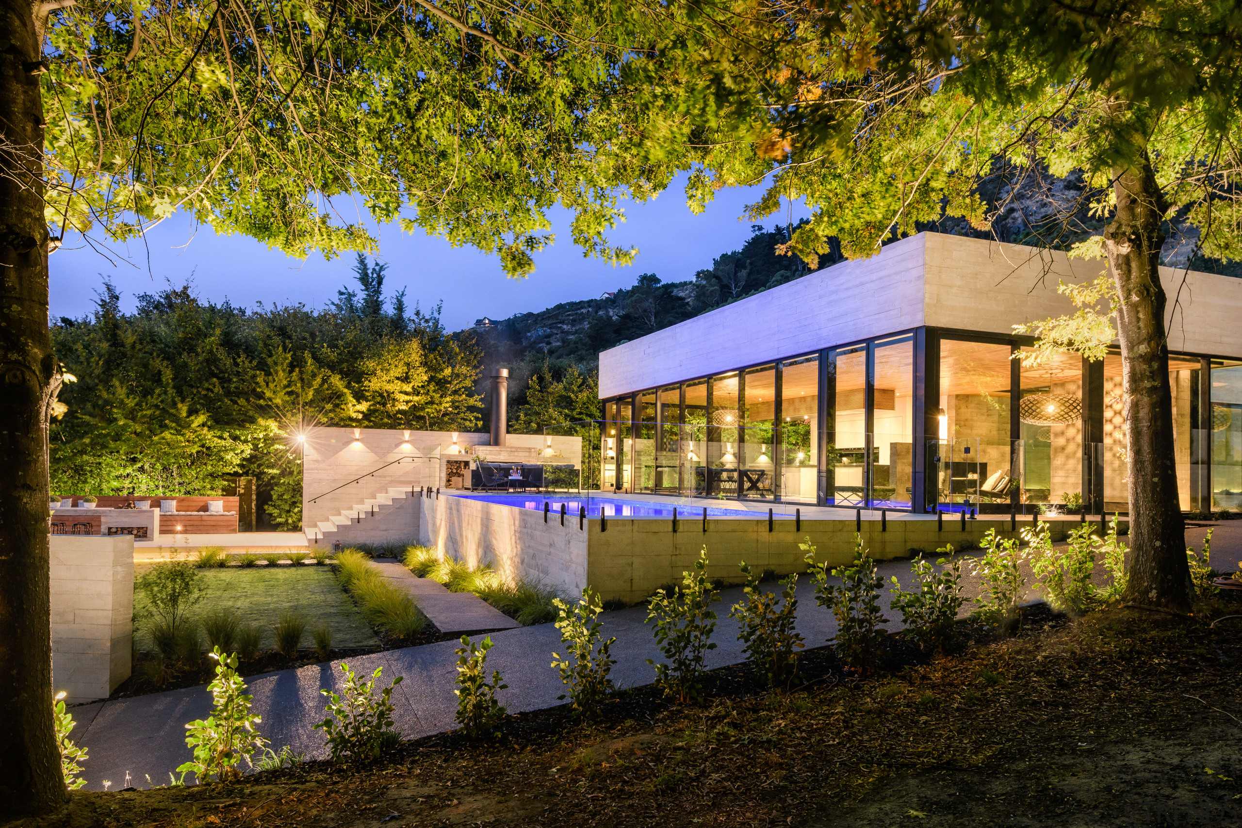 ​​​​​​​The steep driveway in the foreground of this architecture, building, estate, facade, home, house, landscape, leaf, night, plant, property, real estate, reflection, residential area, roof, sky, sunlight, tree, brown