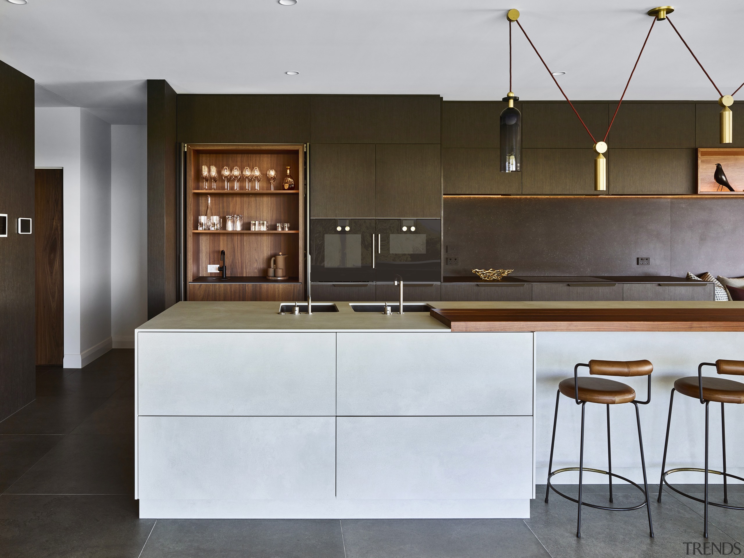 ​​​​​​​This kitchen by designer Darren James features dark architecture, bar stool, cabinetry, countertop, Darren James, wood veneer, porcelain sheeting, drinks station