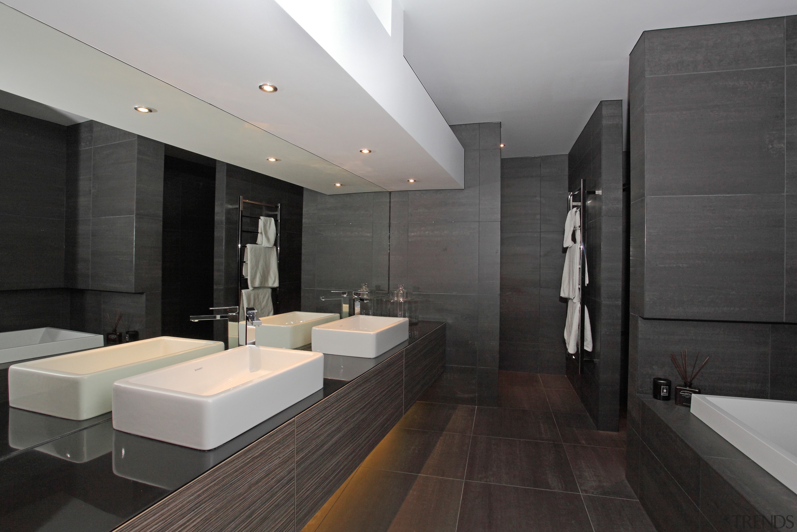 This master bathroom has a modem hotel-like aesthetic, architecture, bathroom, floor, interior design, product design, room, tile, black, gray