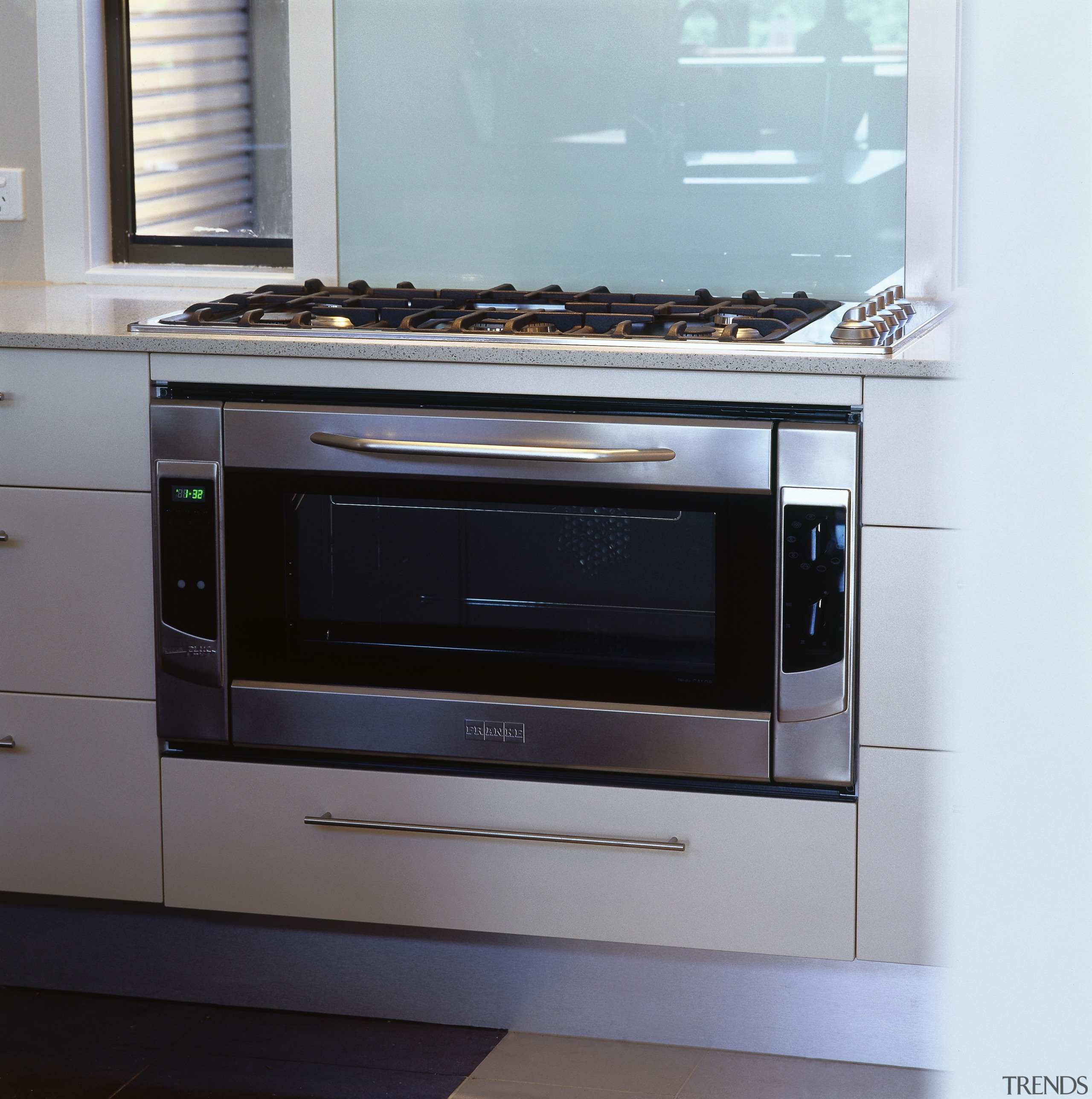 view of the stainless steel franke oven and electronics, gas stove, home appliance, kitchen, kitchen appliance, kitchen stove, major appliance, microwave oven, oven, gray, white, black