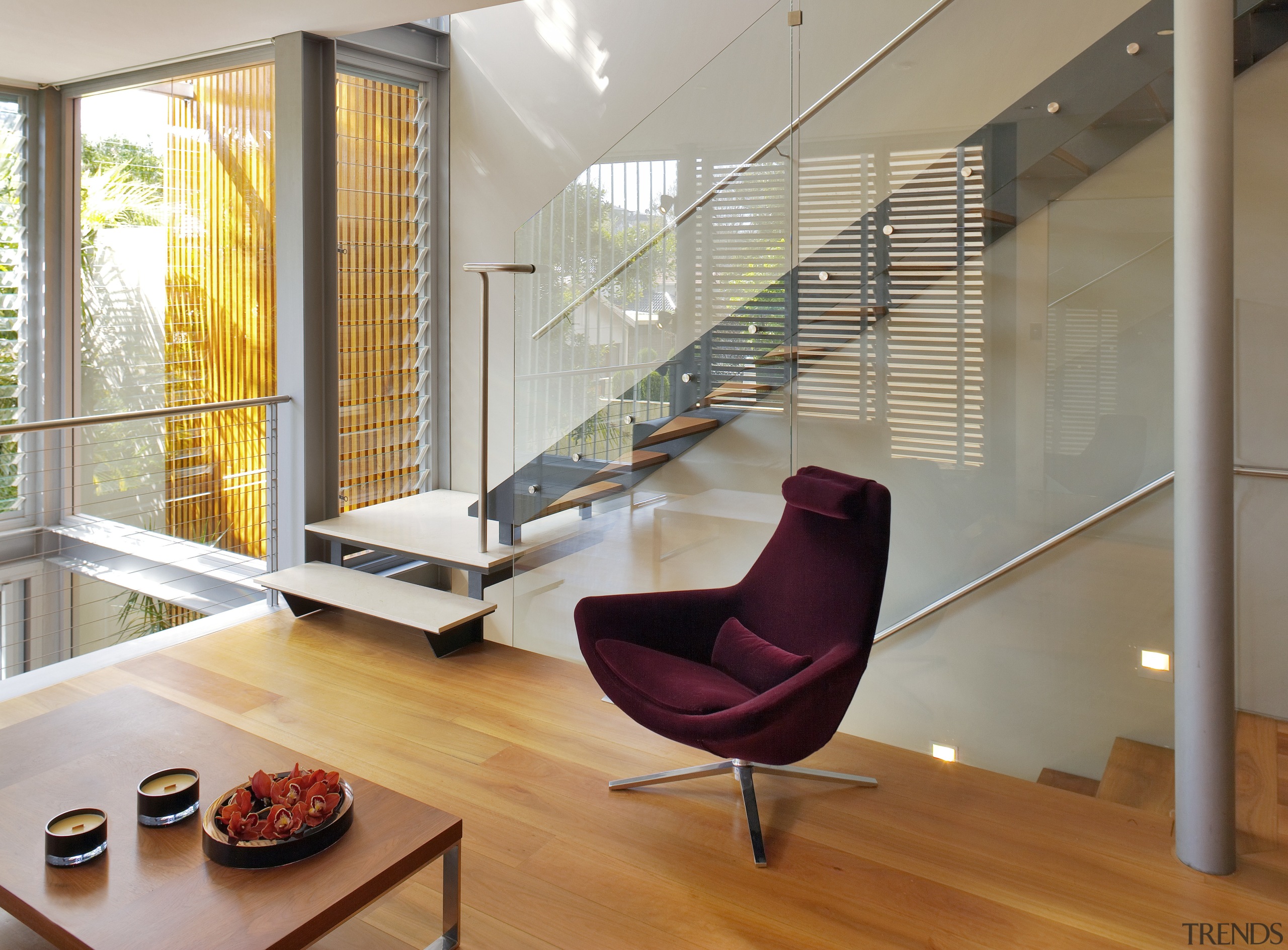 A glazed, three-storey atrium fills this home with architecture, chair, floor, flooring, furniture, hardwood, home, house, interior design, living room, loft, real estate, table, window, wood, gray