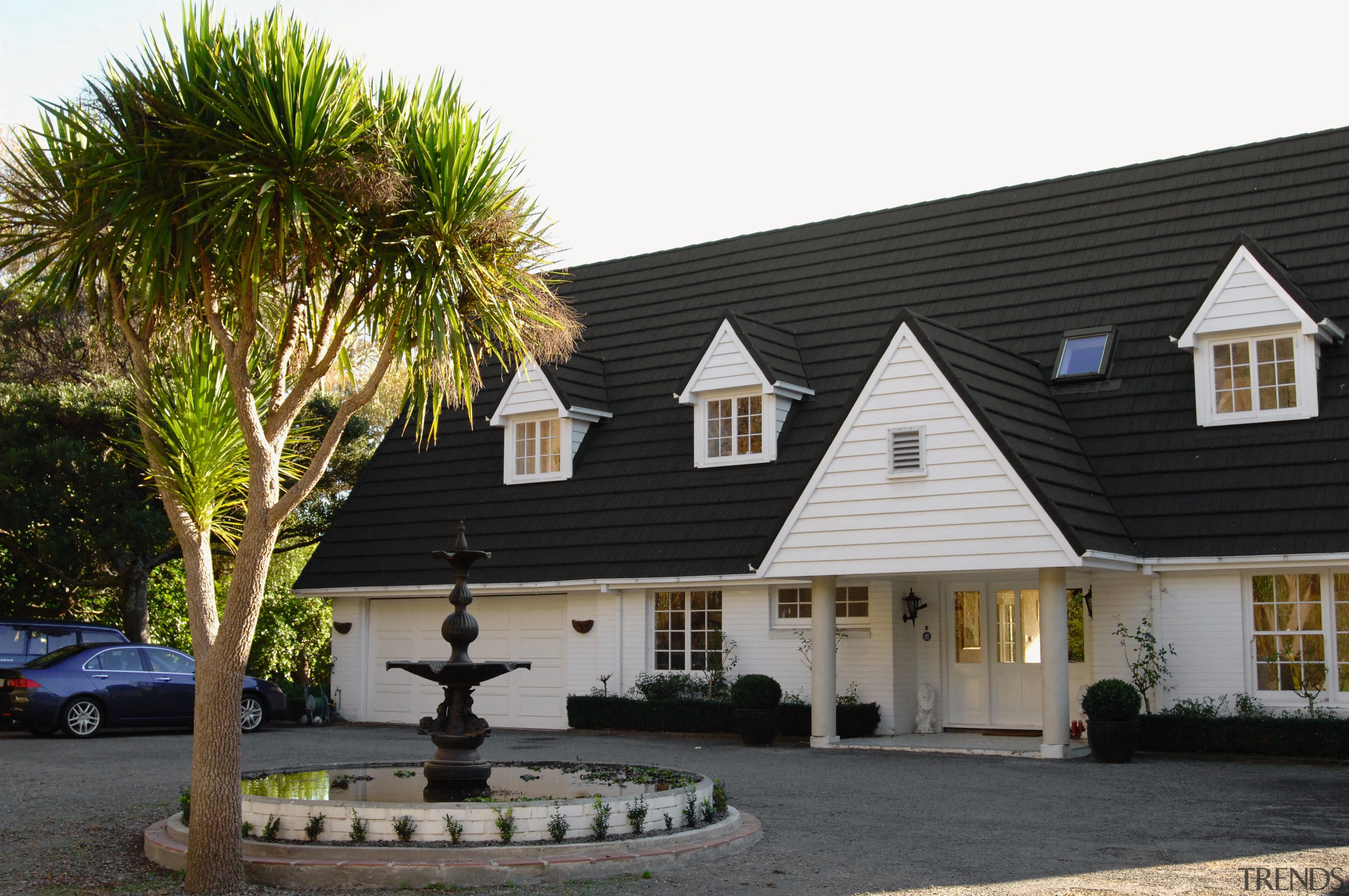 A view of a large home, white wooden building, cottage, estate, facade, farmhouse, home, house, property, real estate, roof, villa, window, black