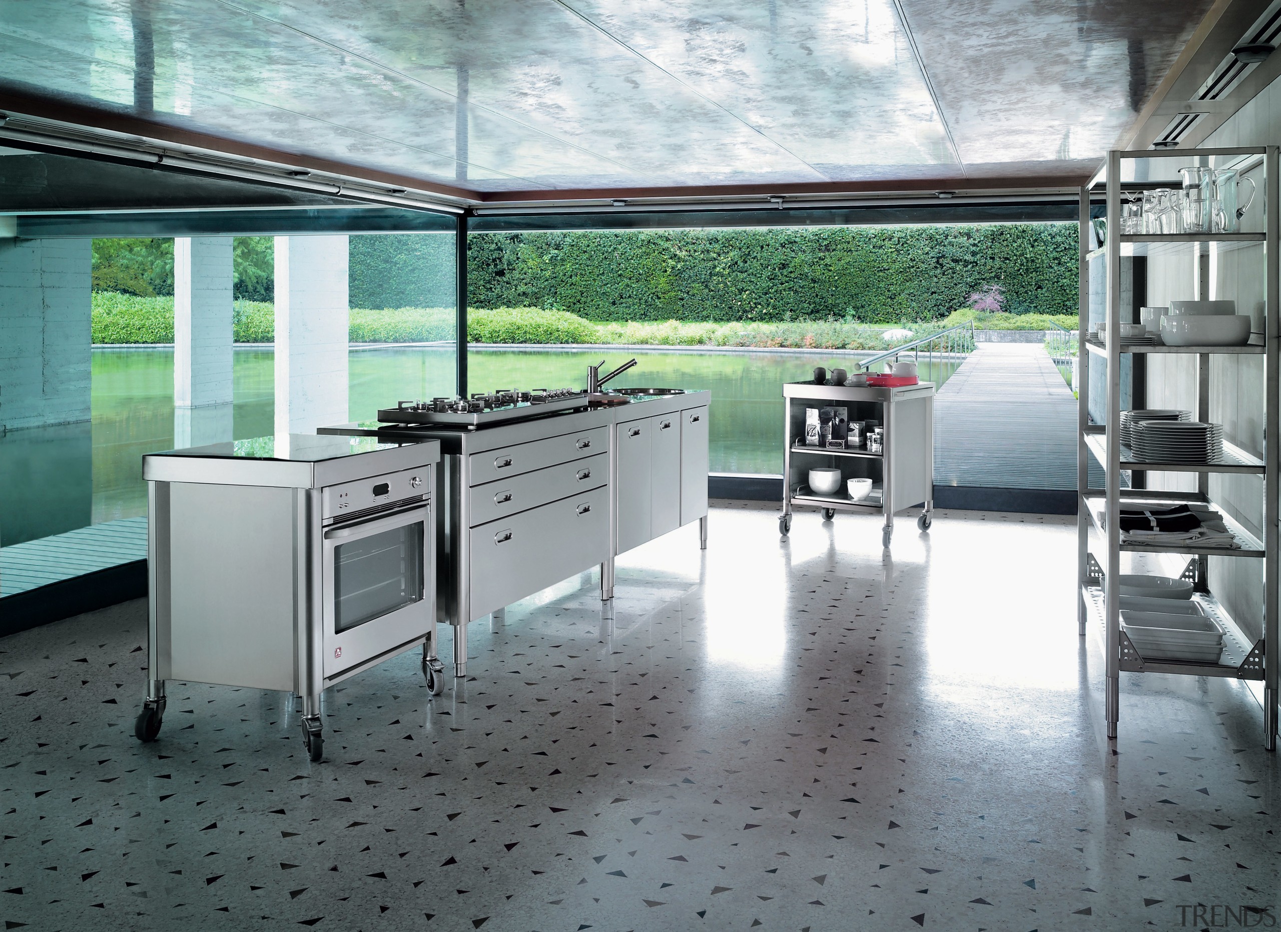 A view of this kitchen featuring stainless steel floor, flooring, gray