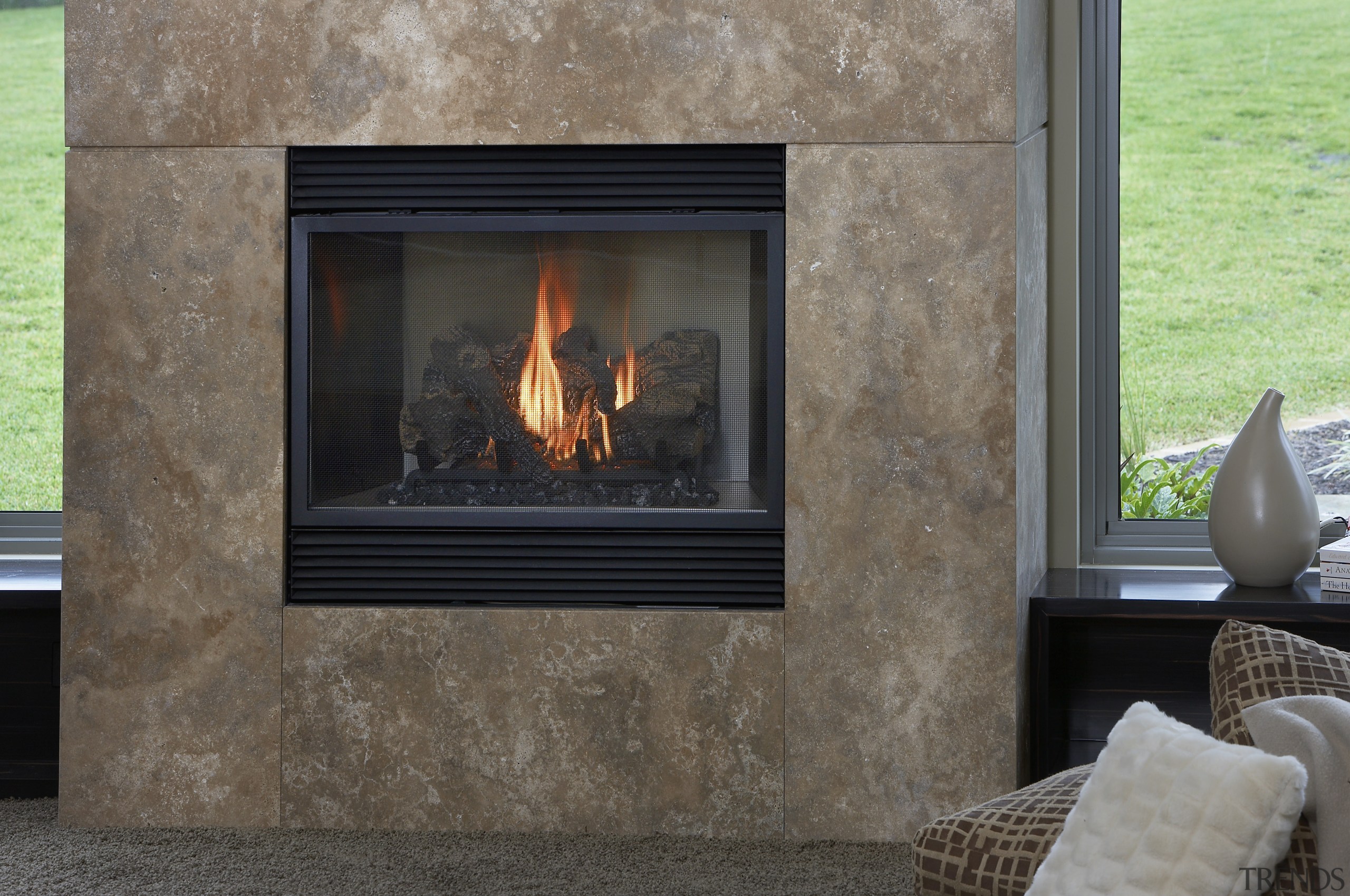 view of a living area which features a fire screen, fireplace, hearth, heat, wood burning stove, gray, black