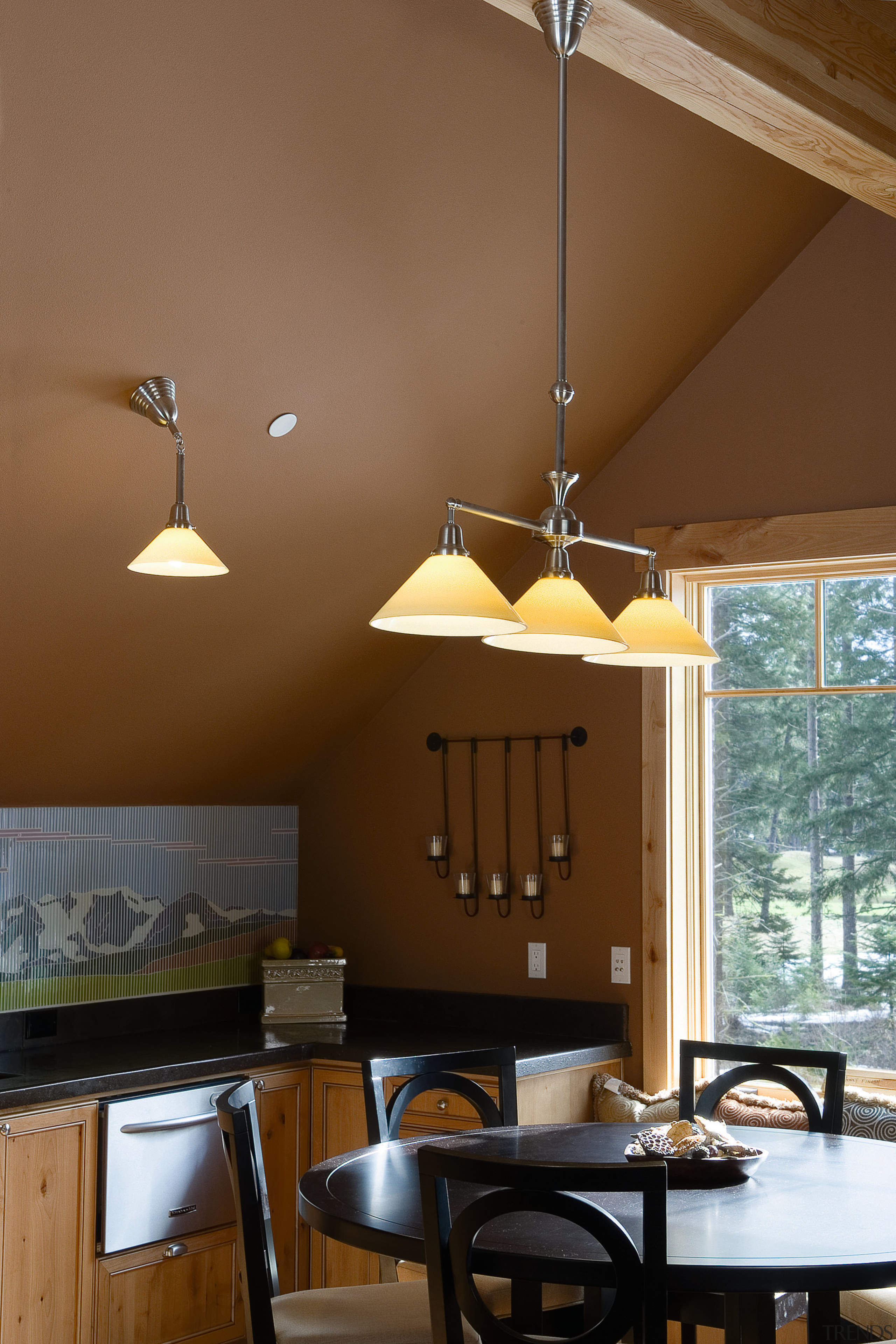 A view of the hang down lighting fixtures ceiling, chandelier, dining room, home, interior design, lamp, light fixture, lighting, lighting accessory, table, wall, brown