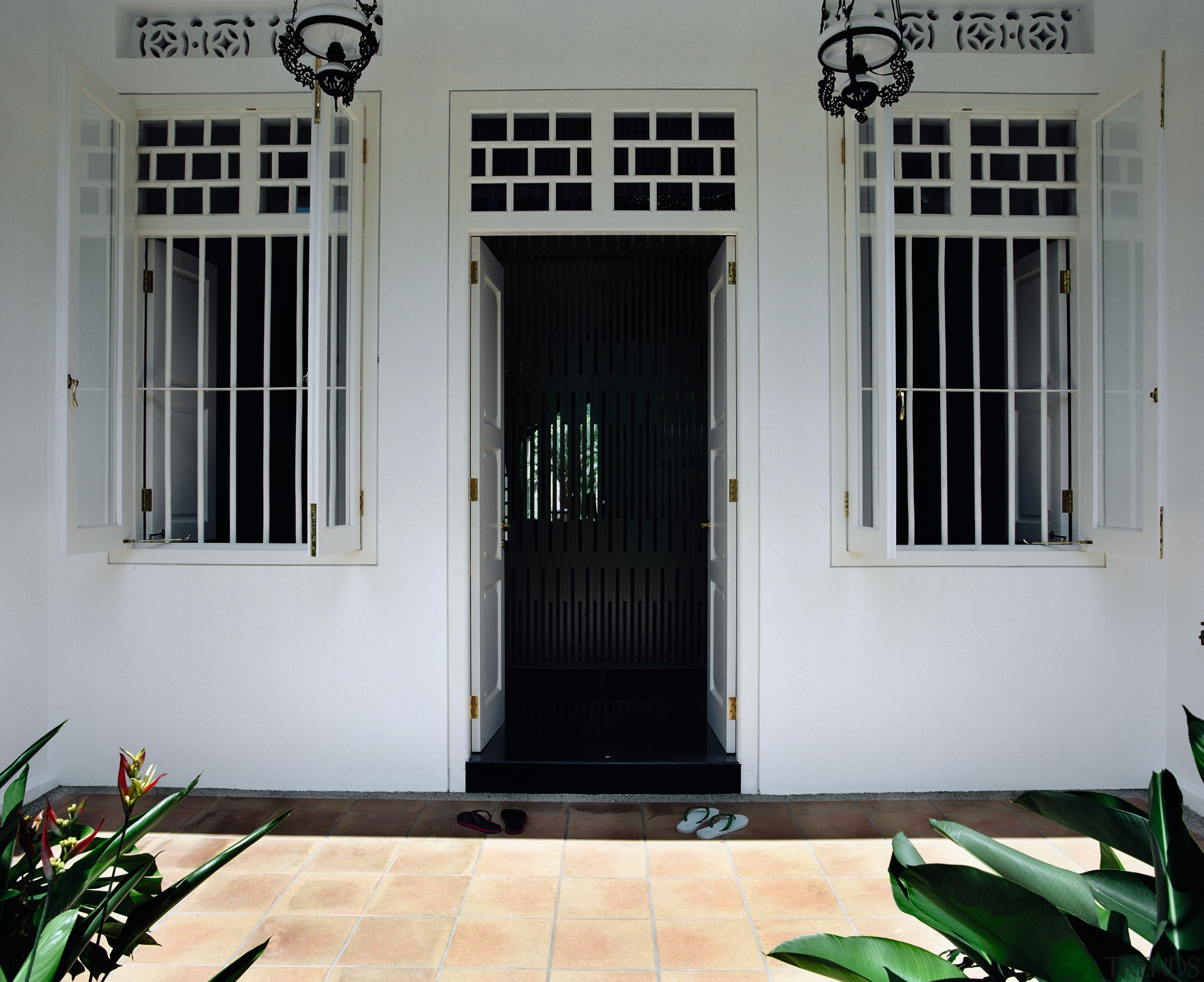 A screen in the entrance foyer allows the door, estate, facade, gate, home, house, iron, property, structure, window, gray, black