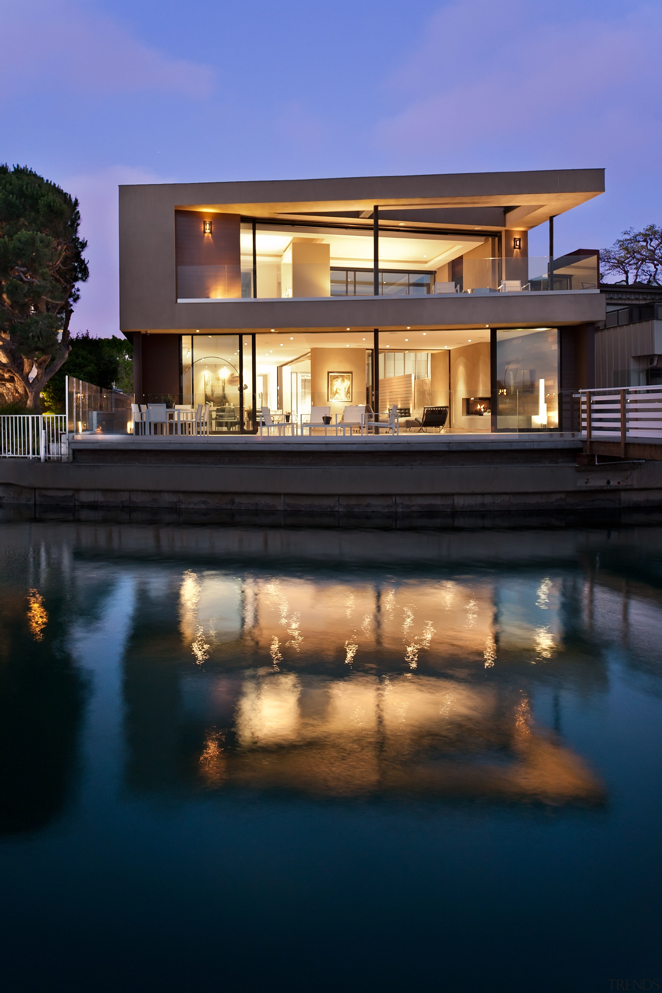 This contemporary home on the waterfront was designed apartment, architecture, building, condominium, estate, evening, home, house, lighting, property, real estate, reflection, residential area, resort, sky, swimming pool, villa, water, blue, black