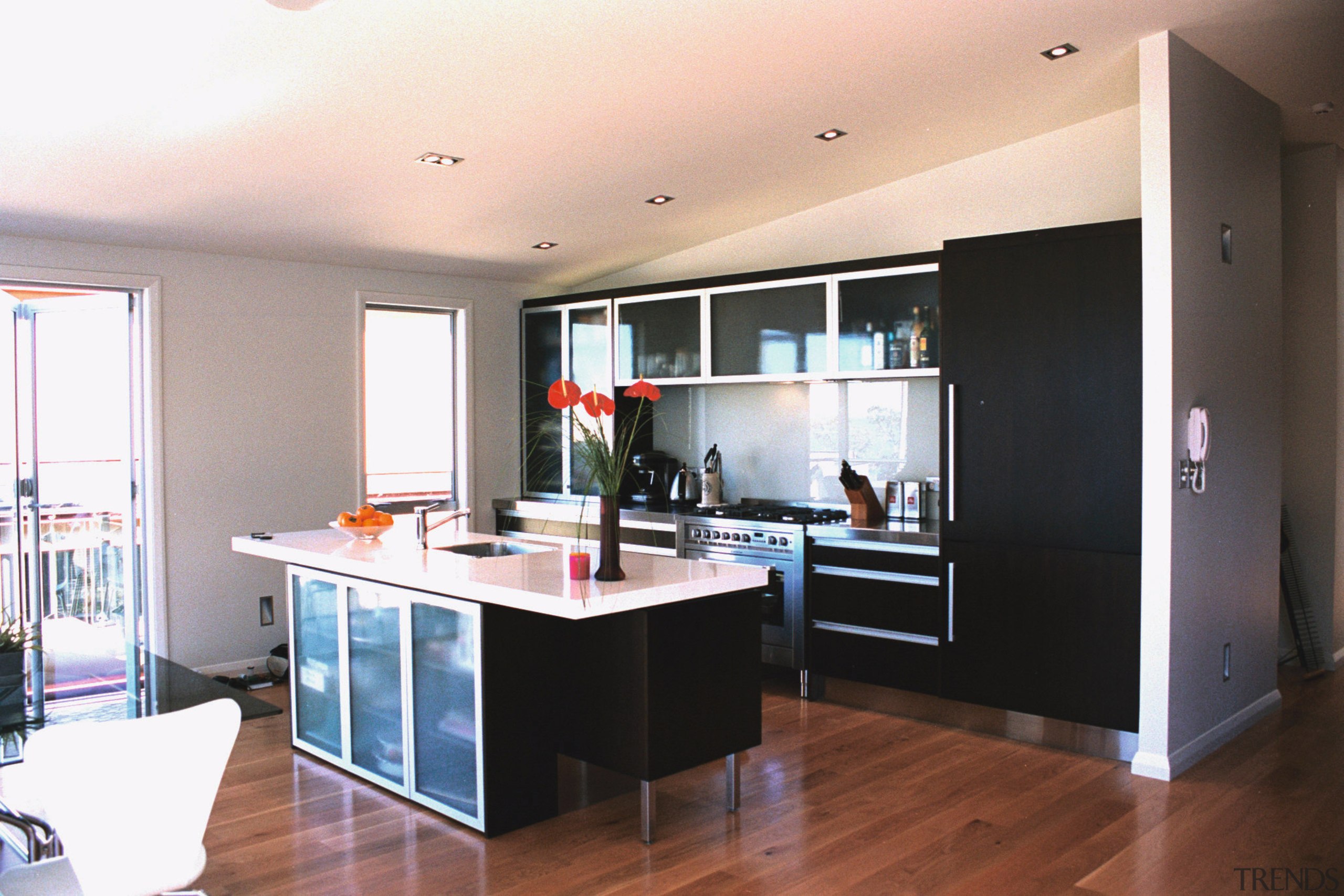 Kitchen area with dark cabinetry, white benchtop and cabinetry, countertop, floor, flooring, interior design, kitchen, real estate, room, white, black