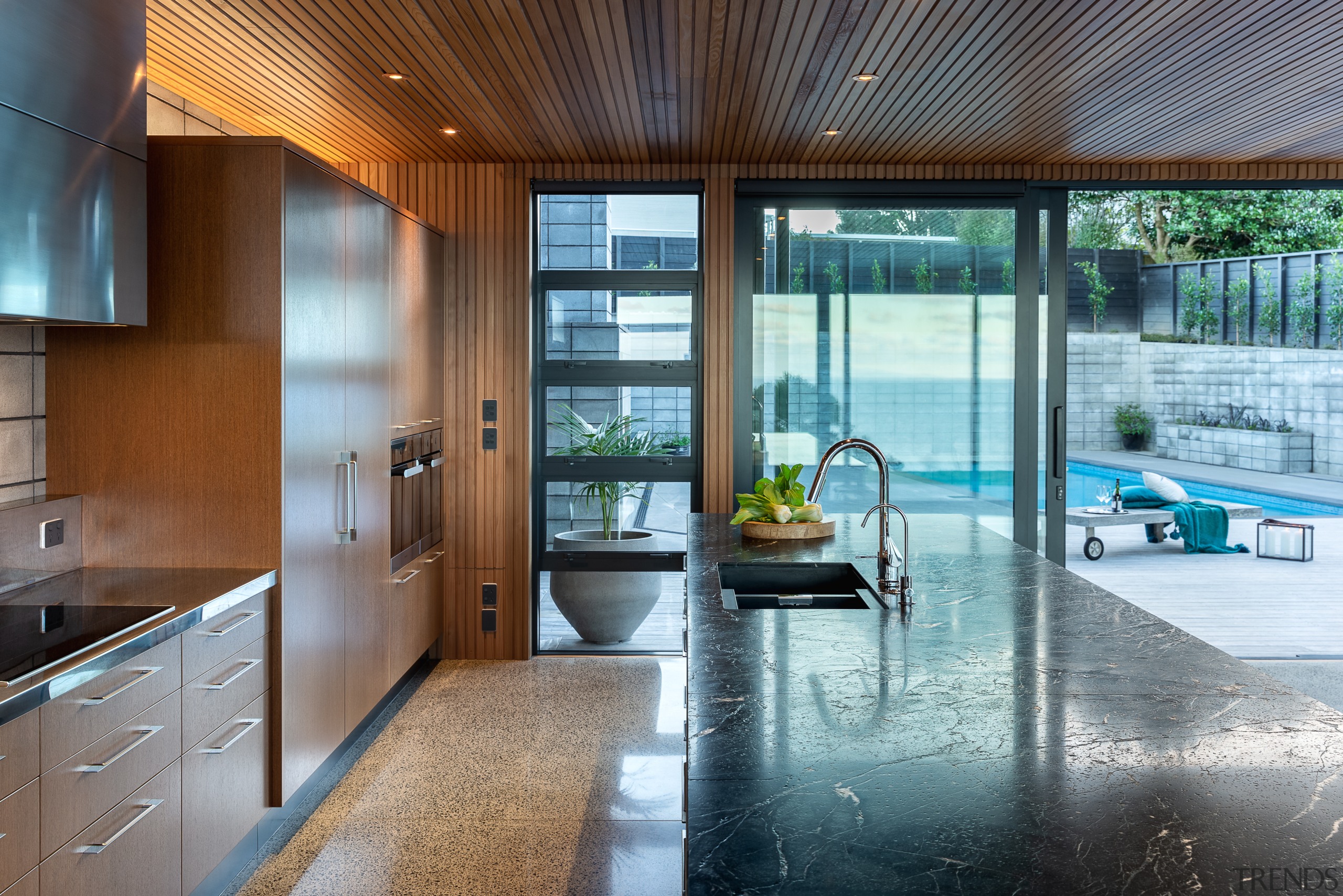 ​​​​​​​Open to the surrounding spaces, this kitchen is apartment, architecture, building, ceiling, countertop, daylighting, estate, floor, flooring, furniture, glass, hardwood, home, house, interior design, kitchen, property, real estate, residential area, room, window, wood